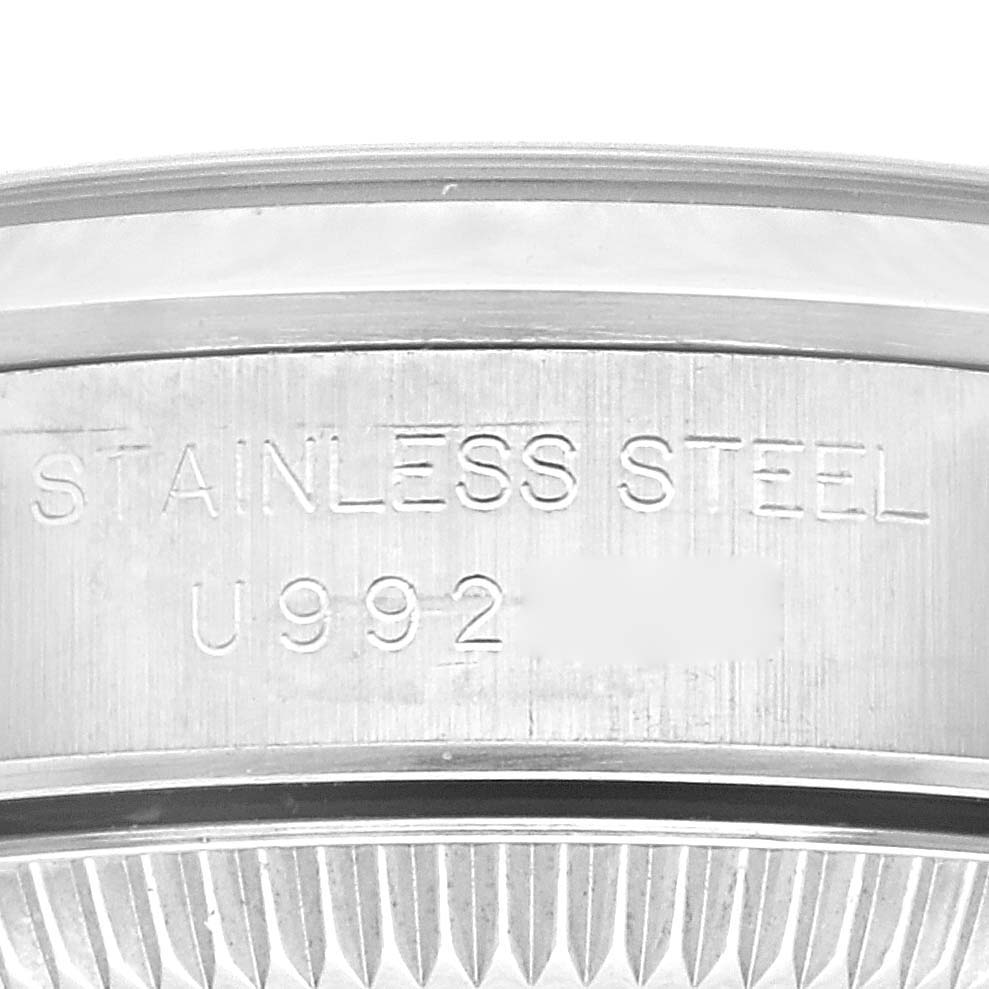 This close-up image shows the side engraving of a Rolex Oyster Perpetual 67180 Women's Stainless Steel Black Dial 67180 Women's Stainless Steel Black Dial watch, focusing on the stainless steel case back.