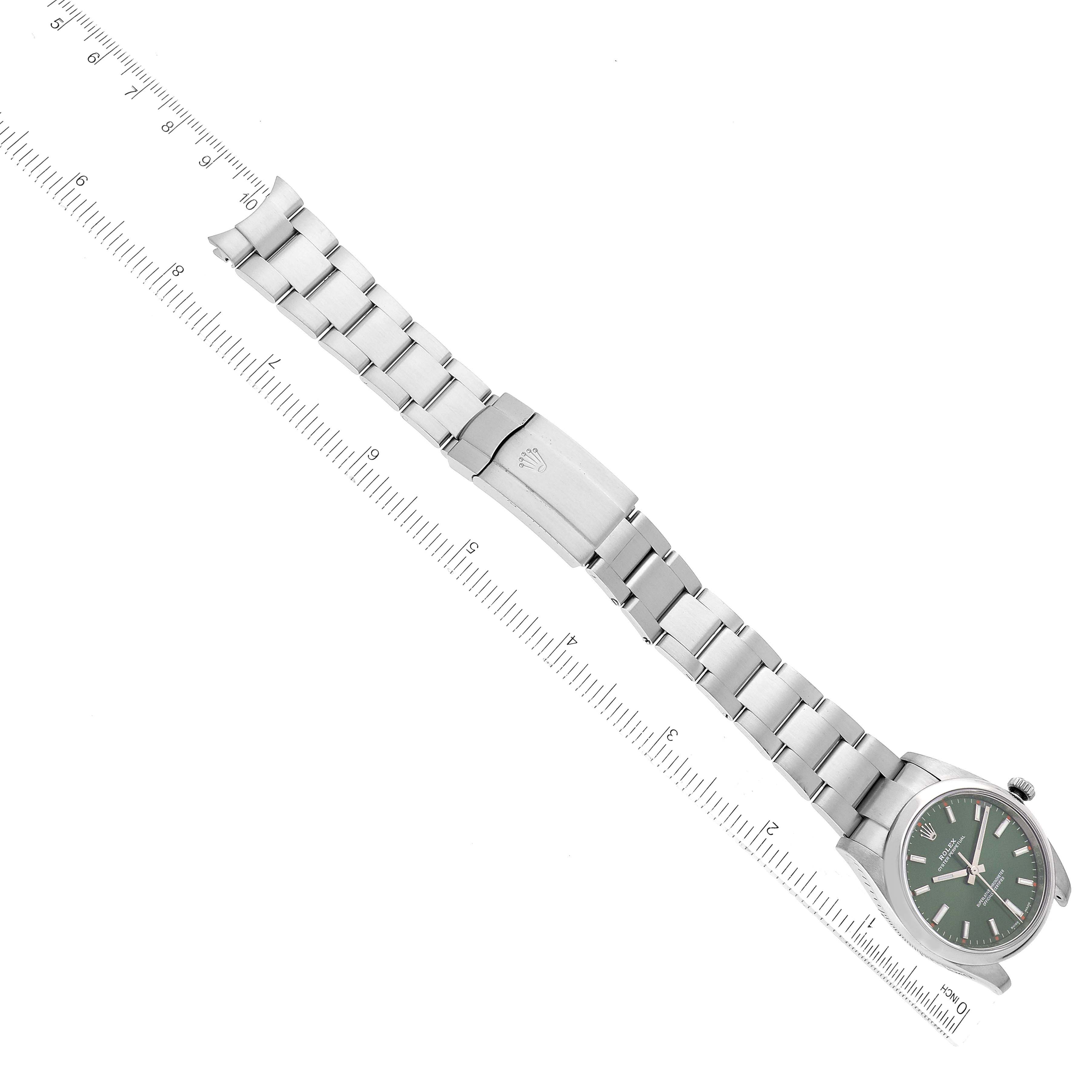 The Rolex Oyster Perpetual 114200 Men
s Stainless Steel Green Dial 114200 Men
s Stainless Steel Green Dial watch is shown from a top-down angle, displaying the face, bracelet, and clasp.