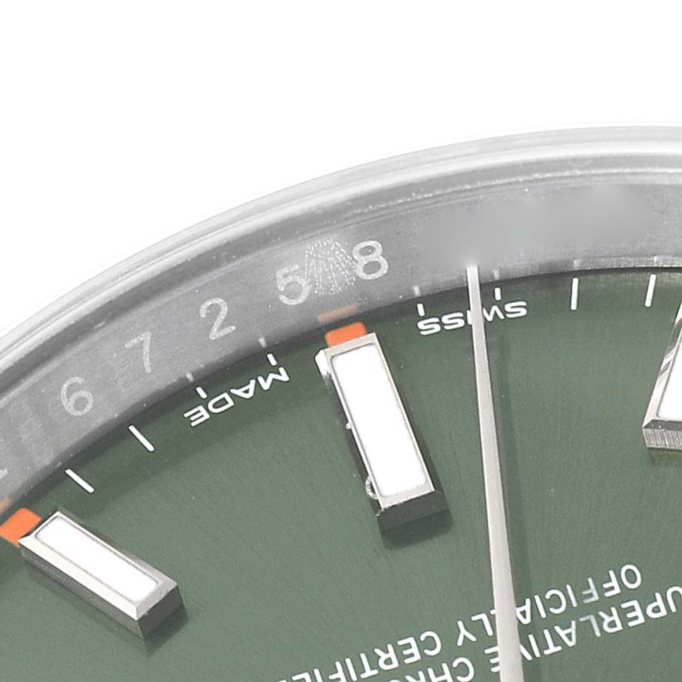 The image shows a close-up of the dial, hands, and part of the chapter ring of a Rolex Oyster Perpetual 114200 Men
s Stainless Steel Green Dial 114200 Men
s Stainless Steel Green Dial watch.