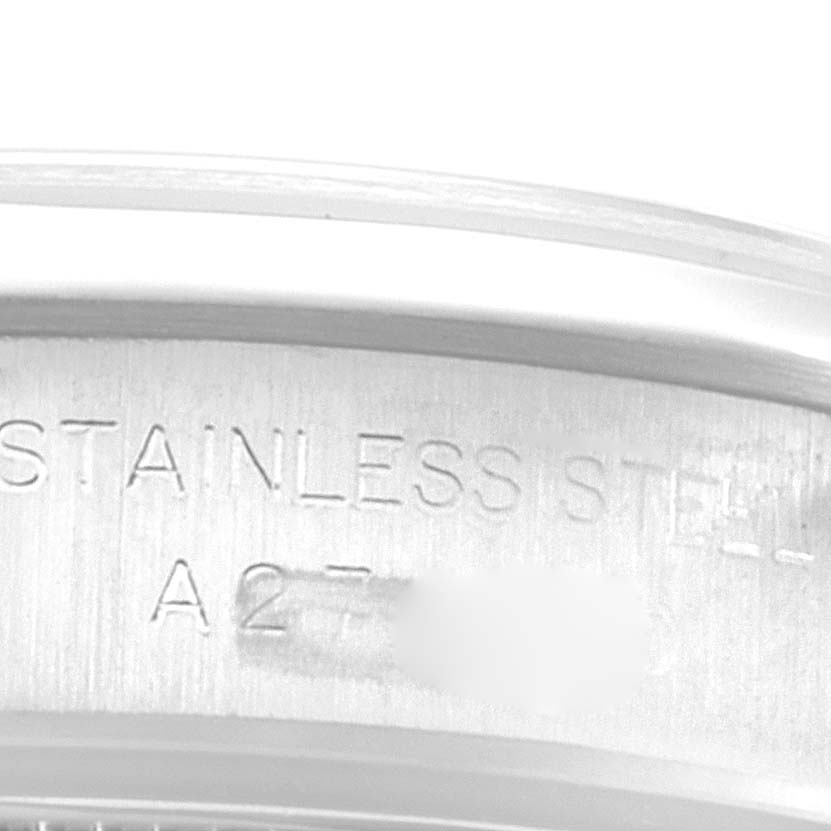 The image shows a close-up of the inner rim of a Rolex Oyster Perpetual 76080 Women
s Stainless Steel Pink Dial 76080 Women
s Stainless Steel Pink Dial watch, engraved with "STAINLESS STEEL" and part of the serial number.