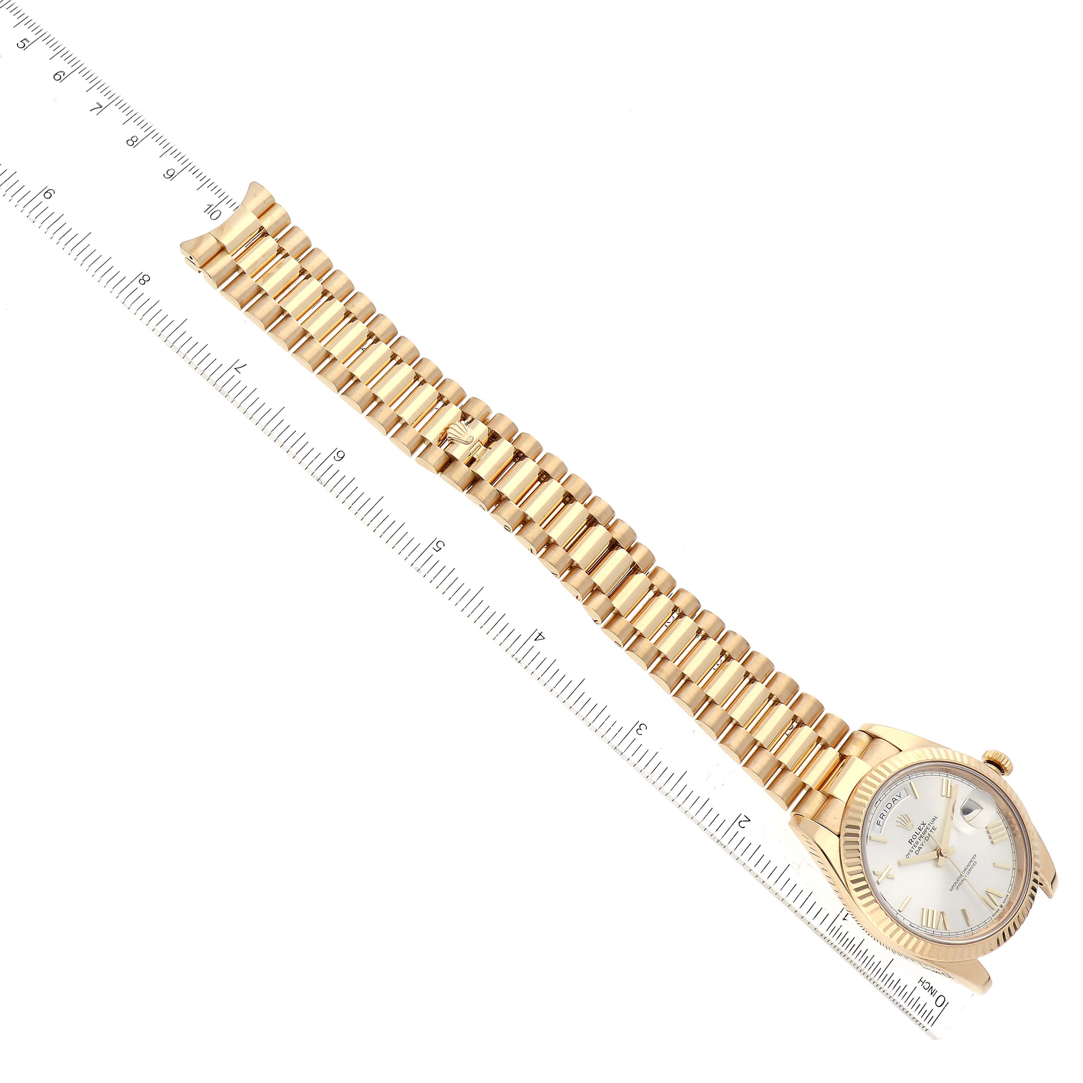 The image shows the Rolex President 228238 Men
s Yellow Gold Silver Dial 228238 Men
s Yellow Gold Silver Dial model watch from a top-down angle, featuring its face, band, and a ruler for scale.