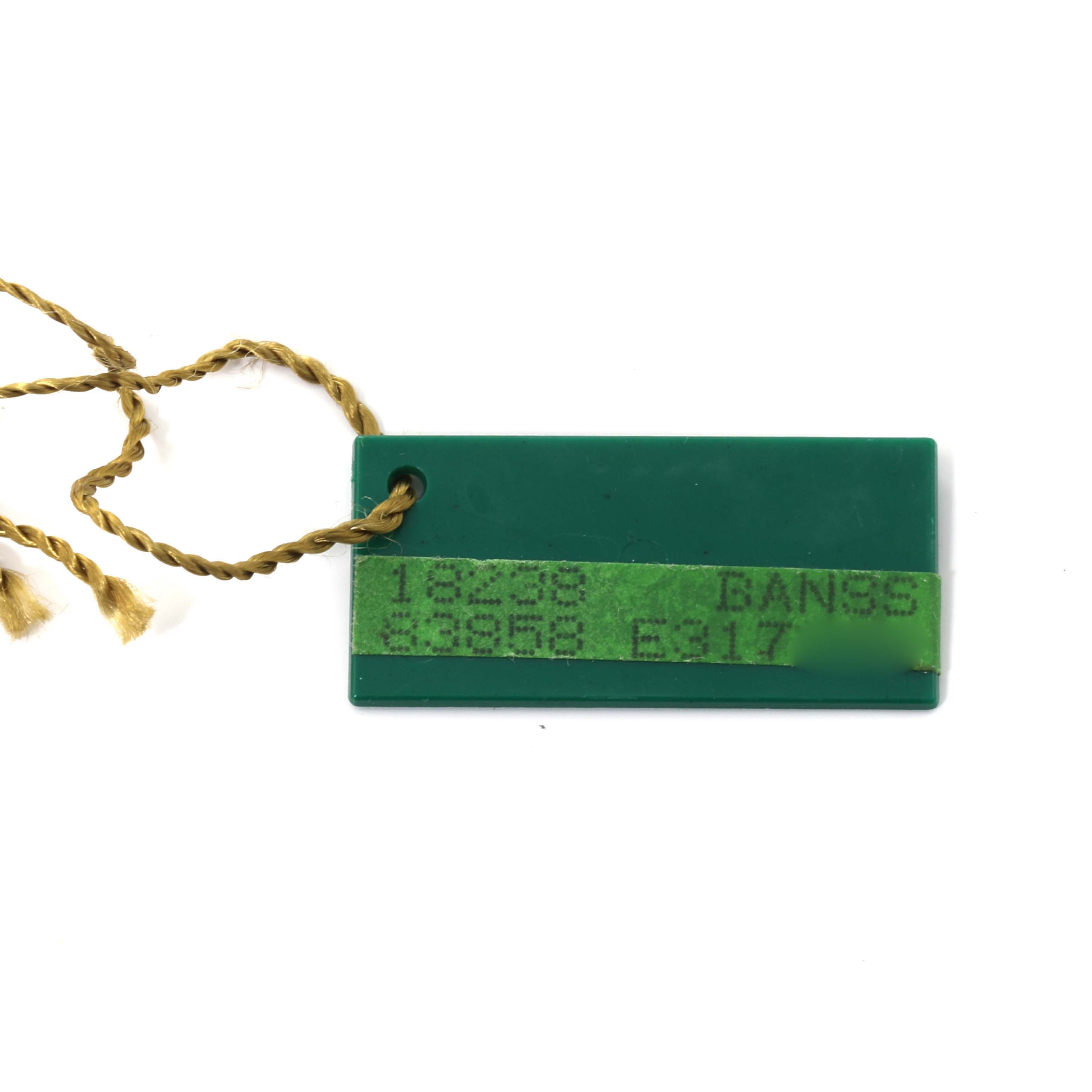 This image shows a green tag with a yellow string, typically found with the Rolex President 18238 Men
s Yellow Gold Champagne Dial 18238 Men
s Yellow Gold Champagne Dial model watch.