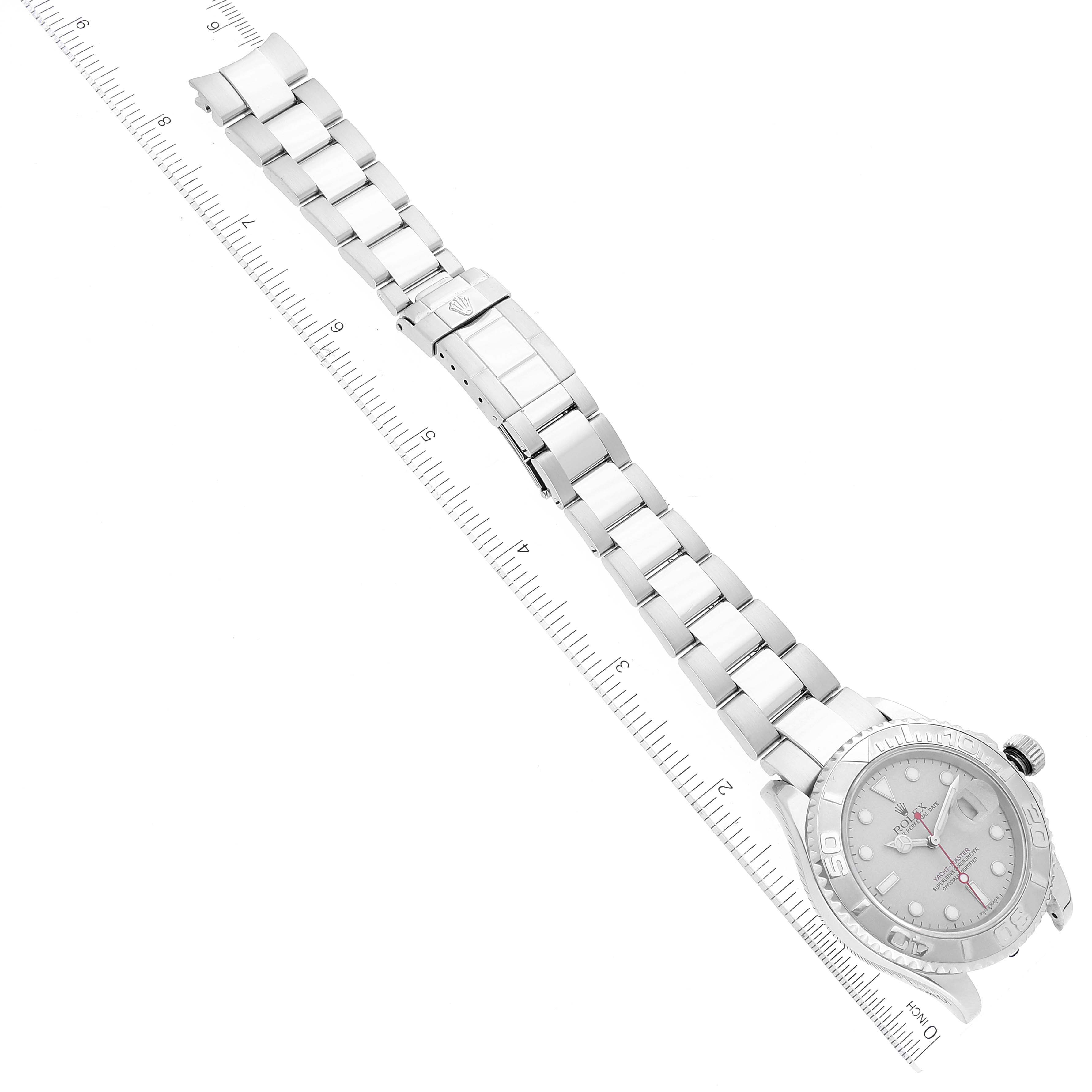 The Rolex Yacht-Master 16622 Men's Stainless Steel Silver Dial 16622 Men's Stainless Steel Silver Dial watch is shown laying flat, highlighting its bracelet, clasp, and watch face, aligned with a ruler for scale.