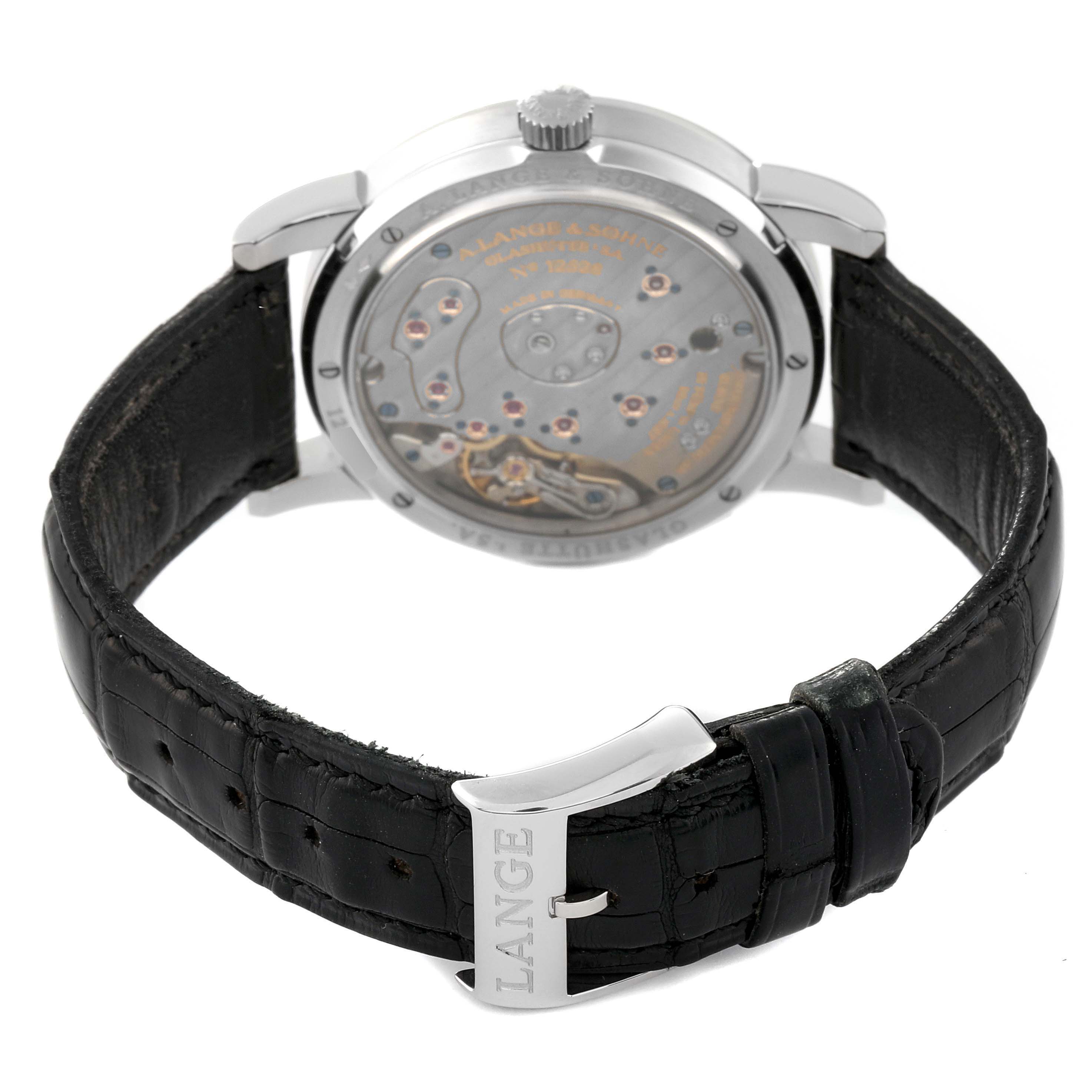 The image shows the back view of an A. Lange 
Sohne Lange 1 101.025 Men
s Platinum Silver Dial watch, focusing on its exposed movement and black leather strap.