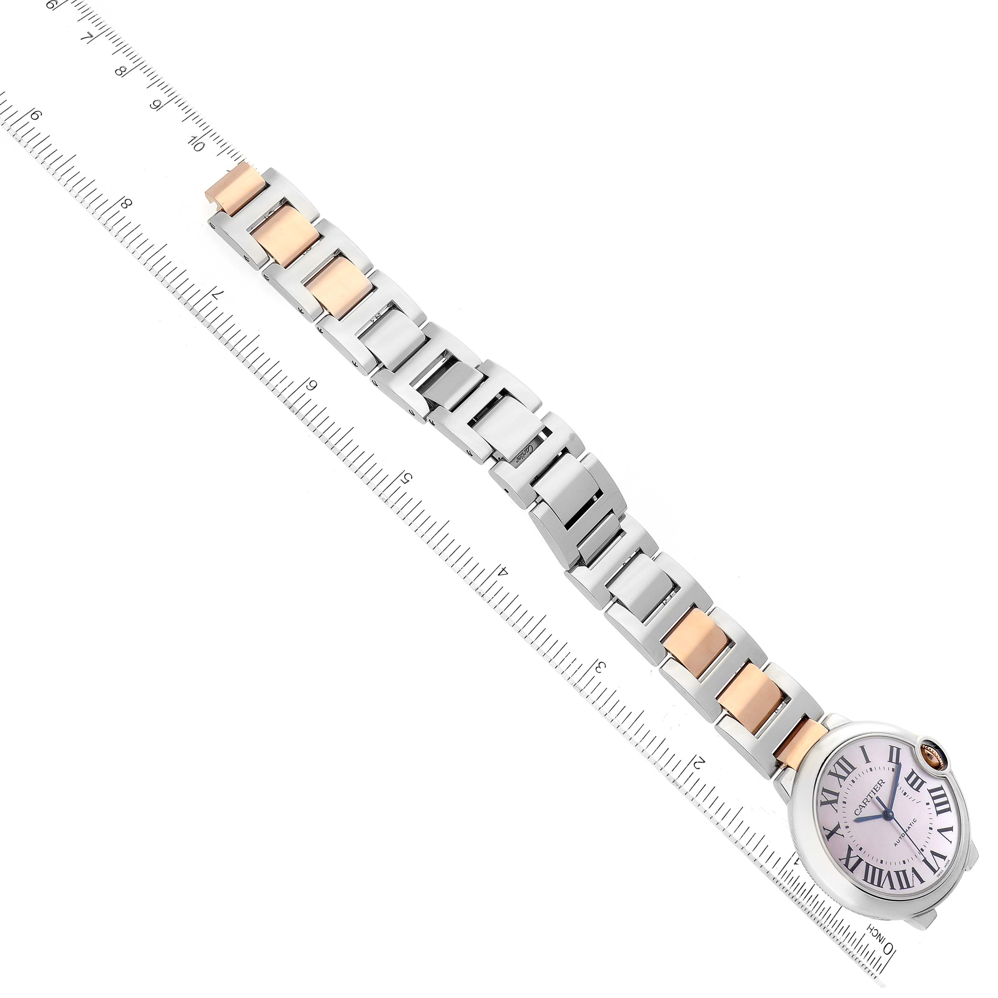 The image shows an overhead view of a Cartier Ballon Bleu W6920033 Women's Steel and Gold (two tone) Mother of Pearl Dial W6920033 Women's Steel and Gold (two tone) Mother of Pearl Dial model watch with a bicolor metal strap beside a ruler.