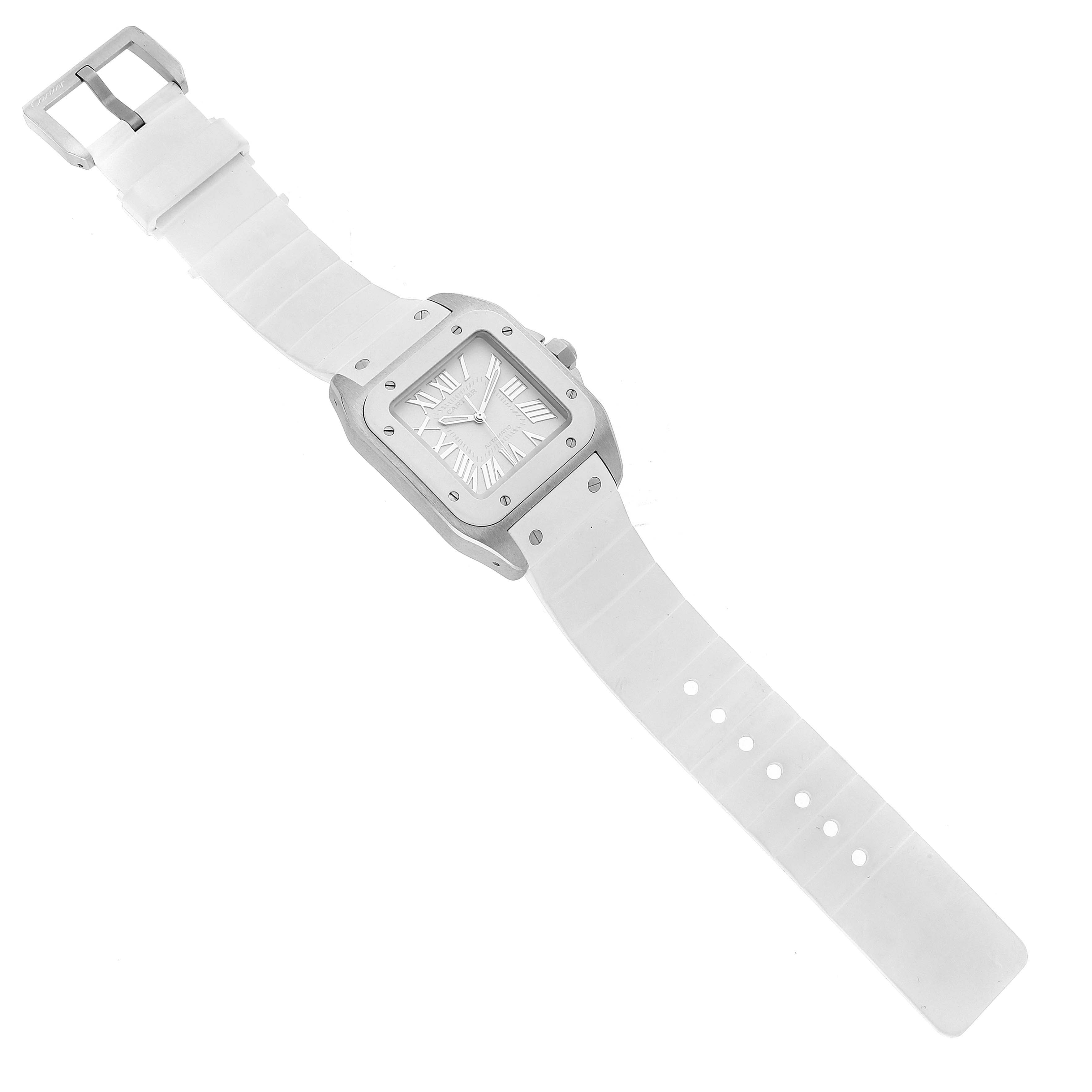 The image shows a Santos model watch by Cartier, viewed from above, displaying its white strap, square dial, and buckle.