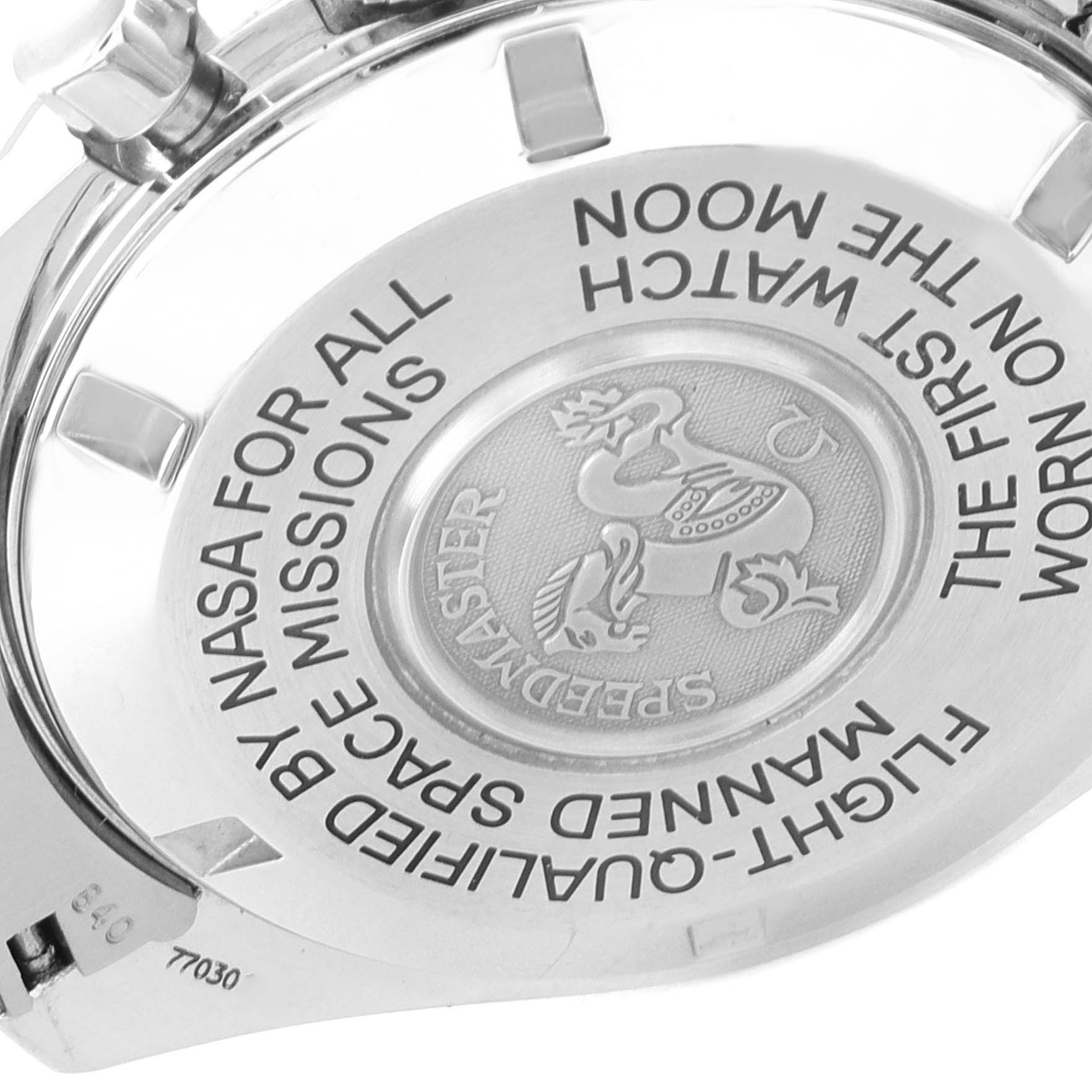 The image shows the back case of an Omega Speedmaster 3875.20.37 Men's Stainless Steel White Dial 3875.20.37 Men's Stainless Steel White Dial watch, highlighting its engravings and logo.