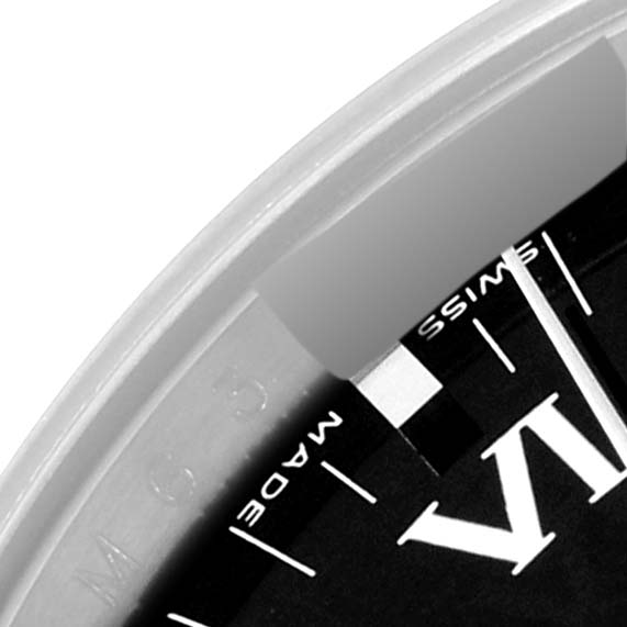 This close-up image of a Date model Rolex watch shows part of the black dial with the "MADE" and "SWISS" markings near the edge.