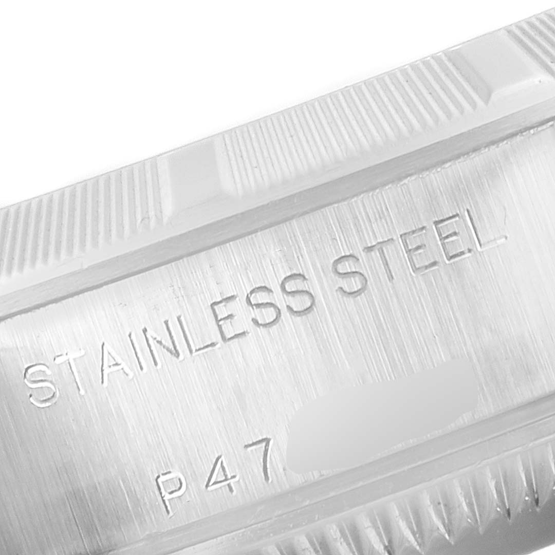 The image shows a close-up of the edge of a stainless steel Rolex Date 79190 Women's Stainless Steel White Dial 79190 Women's Stainless Steel White Dial watch case, with part of its engraved markings visible.