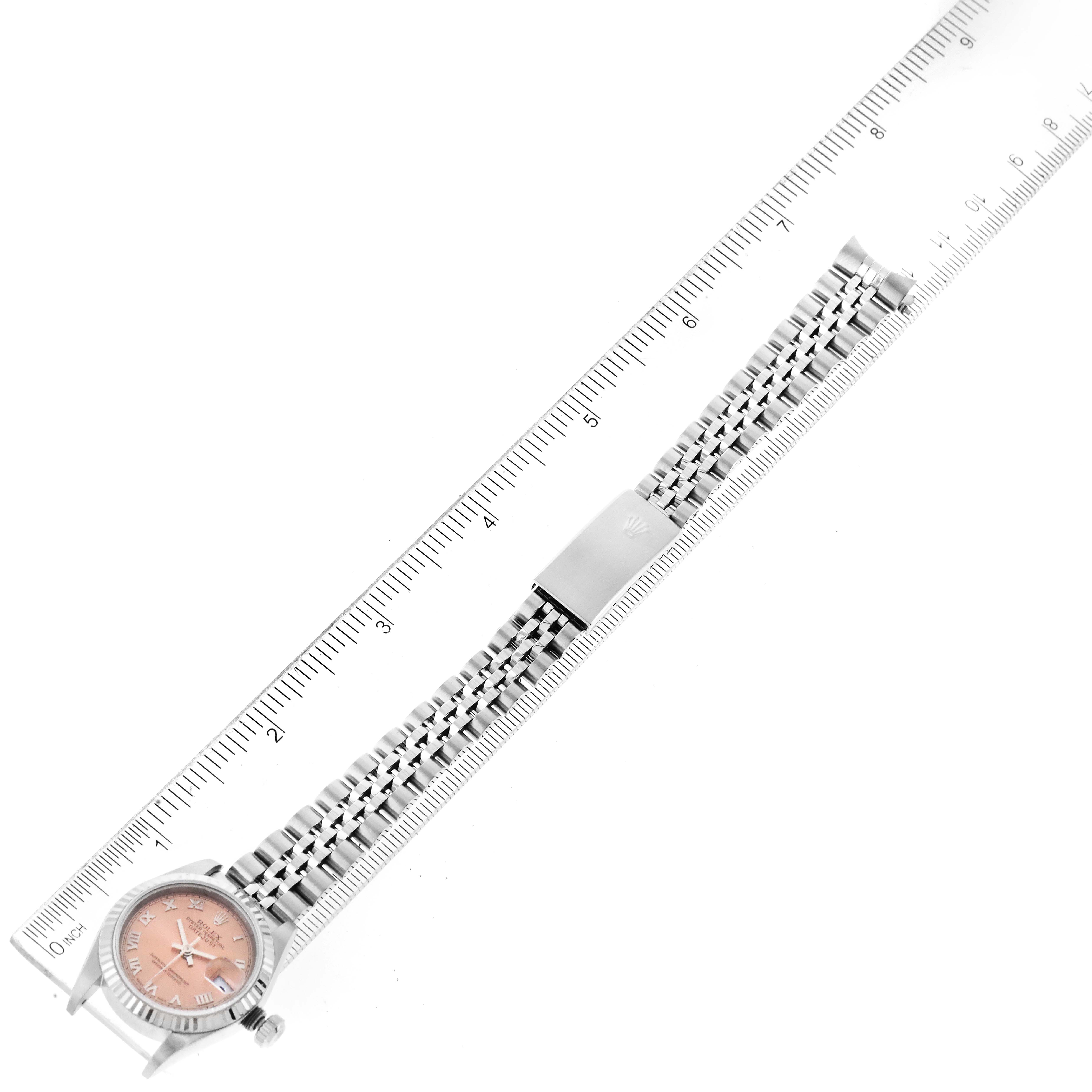 The image shows a top-down view of a Rolex Datejust 79174 Women's Stainless Steel Pink Dial 79174 Women's Stainless Steel Pink Dial watch with a pink dial, a Jubilee bracelet, and a partial clasp, measured against a ruler.