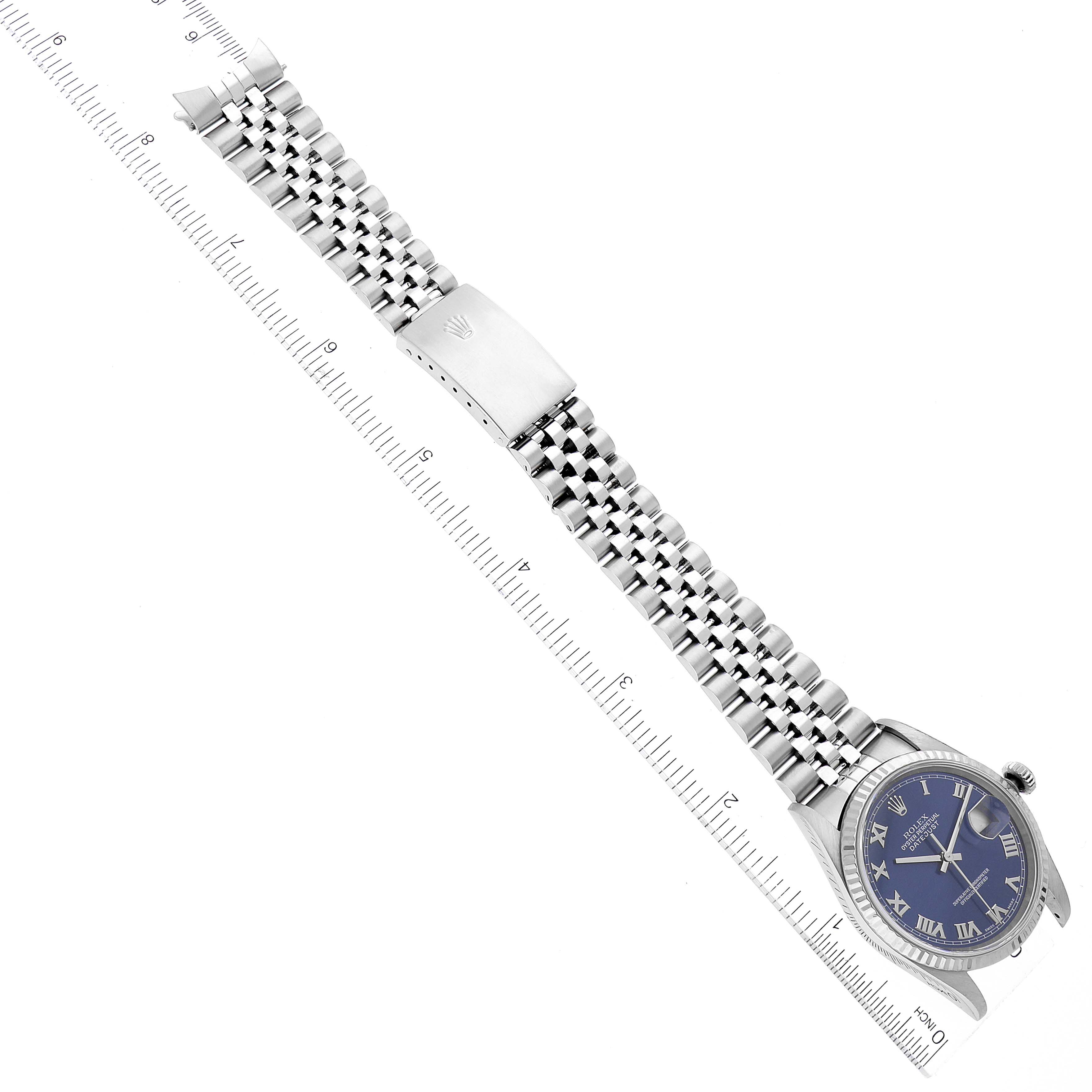 This image shows a top view of a Rolex Datejust 16234 Men's Stainless Steel Blue Dial 16234 Men's Stainless Steel Blue Dial watch with its dial, bezel, crown, and bracelet laid out along a ruler.