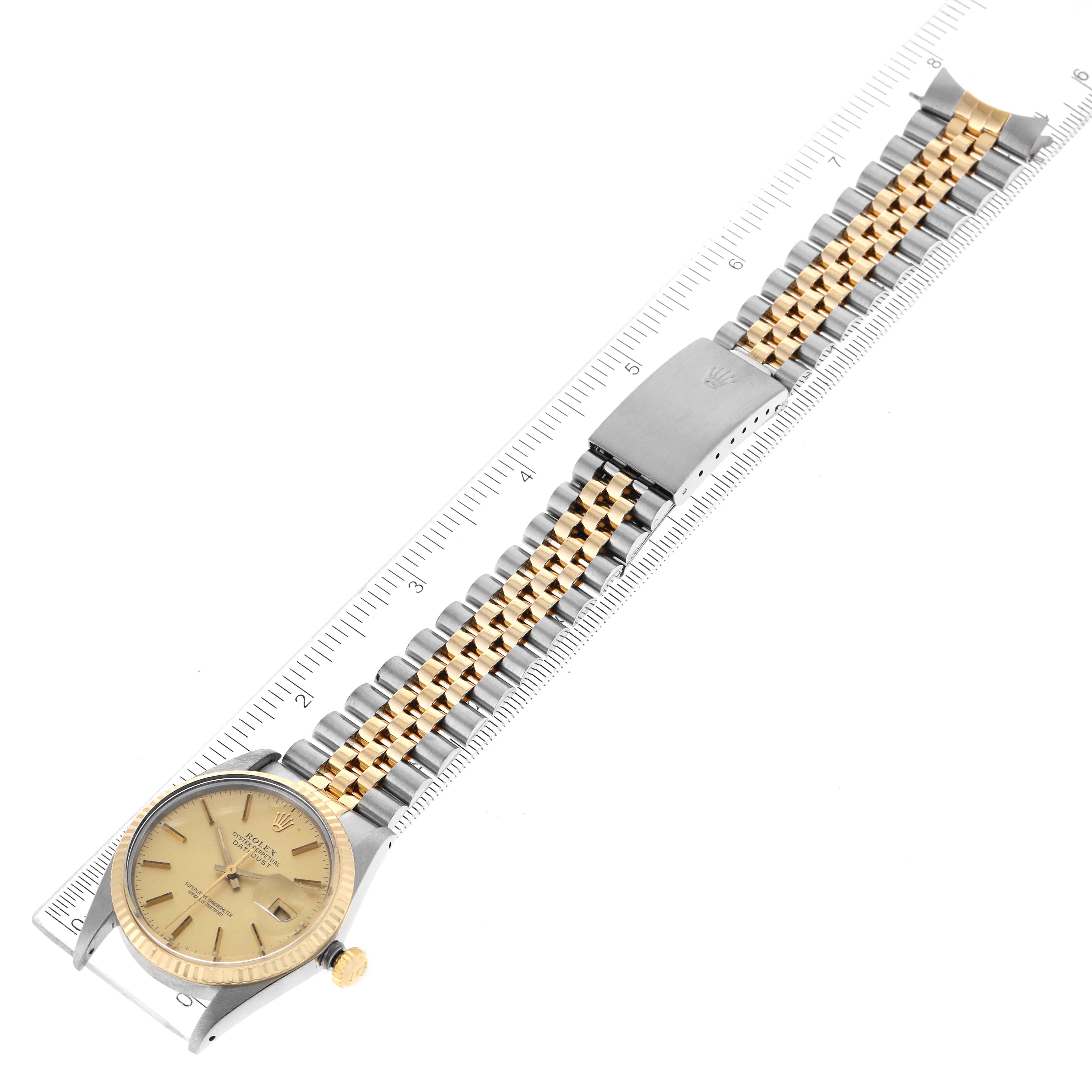 This image shows a Rolex Vintage Collection 16013 Men's Steel and Gold (two tone) Champagne Dial 16013 Men's Steel and Gold (two tone) Champagne Dial watch, featuring a gold and silver band, face, and clasp, laid flat with a ruler for scale.