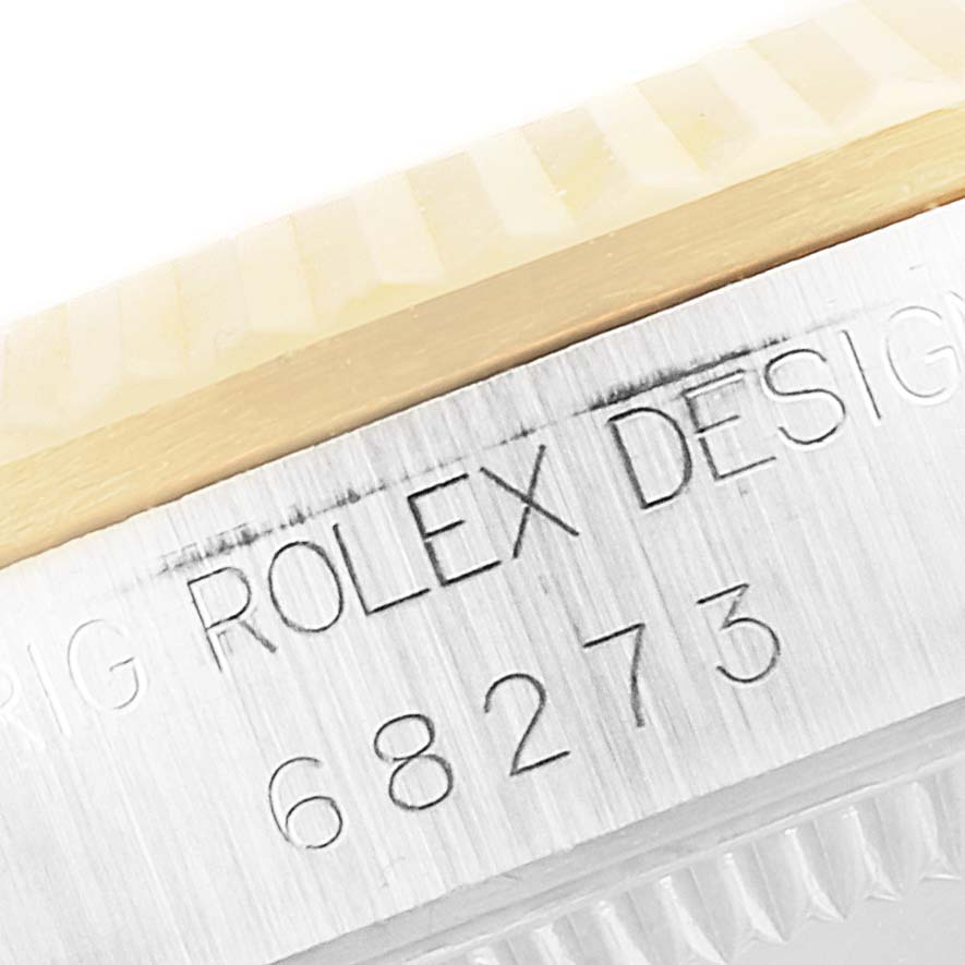 The image shows a close-up of the model number and part of the bezel of a Mid-Size Rolex watch.