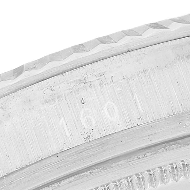 This image shows a close-up of the serial number engraving on the edge of a Rolex Vintage Collection 1601 Men's Stainless Steel Black Dial 1601 Men's Stainless Steel Black Dial watch bezel.