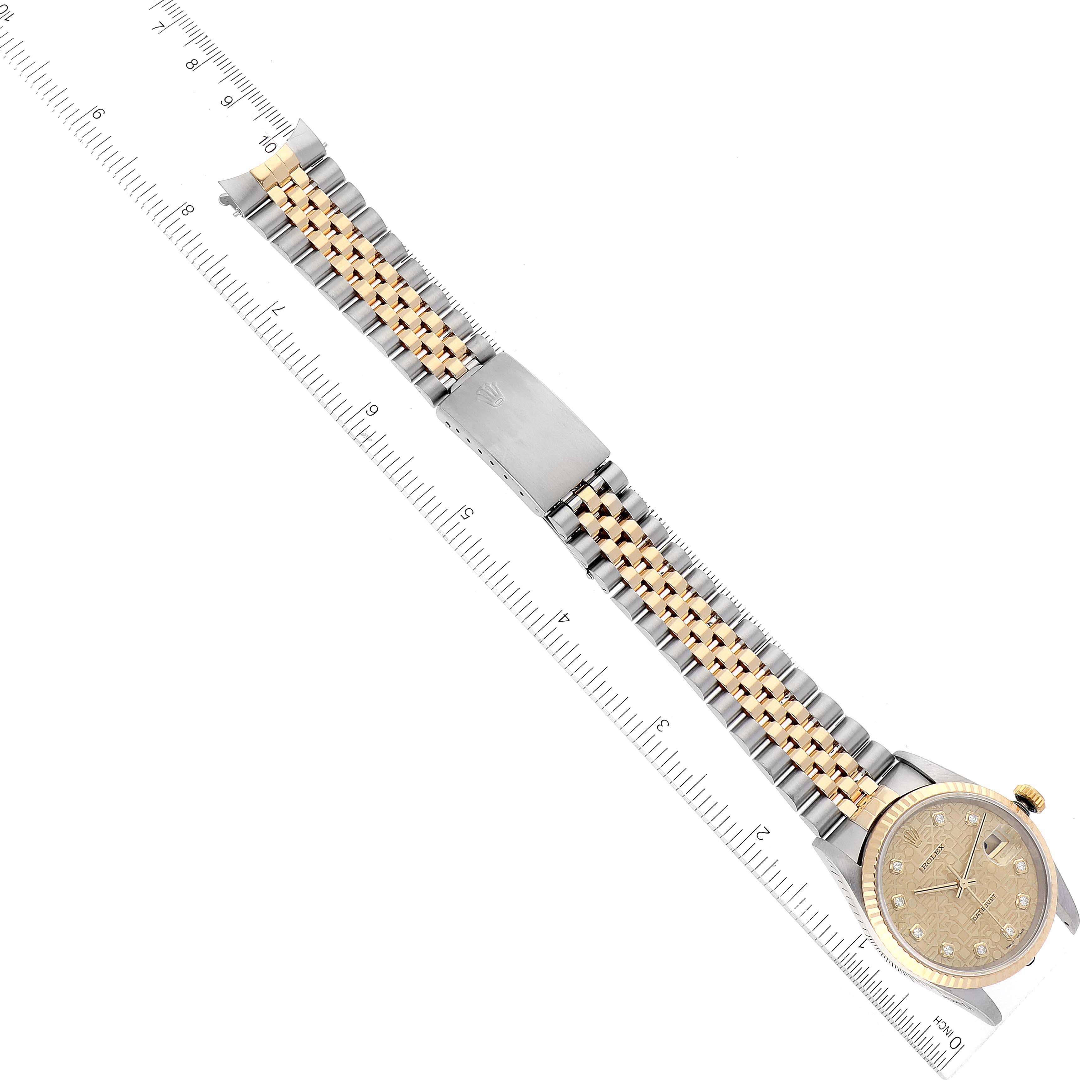 The image depicts a Rolex Datejust 16233 Men's Steel and Gold (two tone) Champagne Dial 16233 Men's Steel and Gold (two tone) Champagne Dial watch laid flat, showcasing its gold and silver band alongside a ruler for scale.