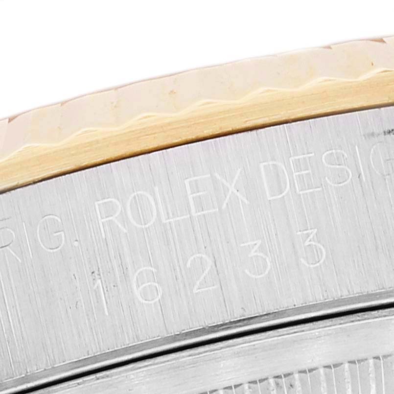 The image shows an angled close-up of the side of a Rolex Datejust 16233 Men's Steel and Gold (two tone) Champagne Dial 16233 Men's Steel and Gold (two tone) Champagne Dial watch, focusing on the inscription and side of the bezel.