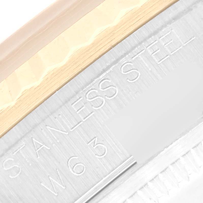 This close-up shows part of the bezel and the engraved text "STAINLESS STEEL" on a Rolex Datejust 16233 Men's Steel and Gold (two tone) Champagne Dial 16233 Men's Steel and Gold (two tone) Champagne Dial watch.