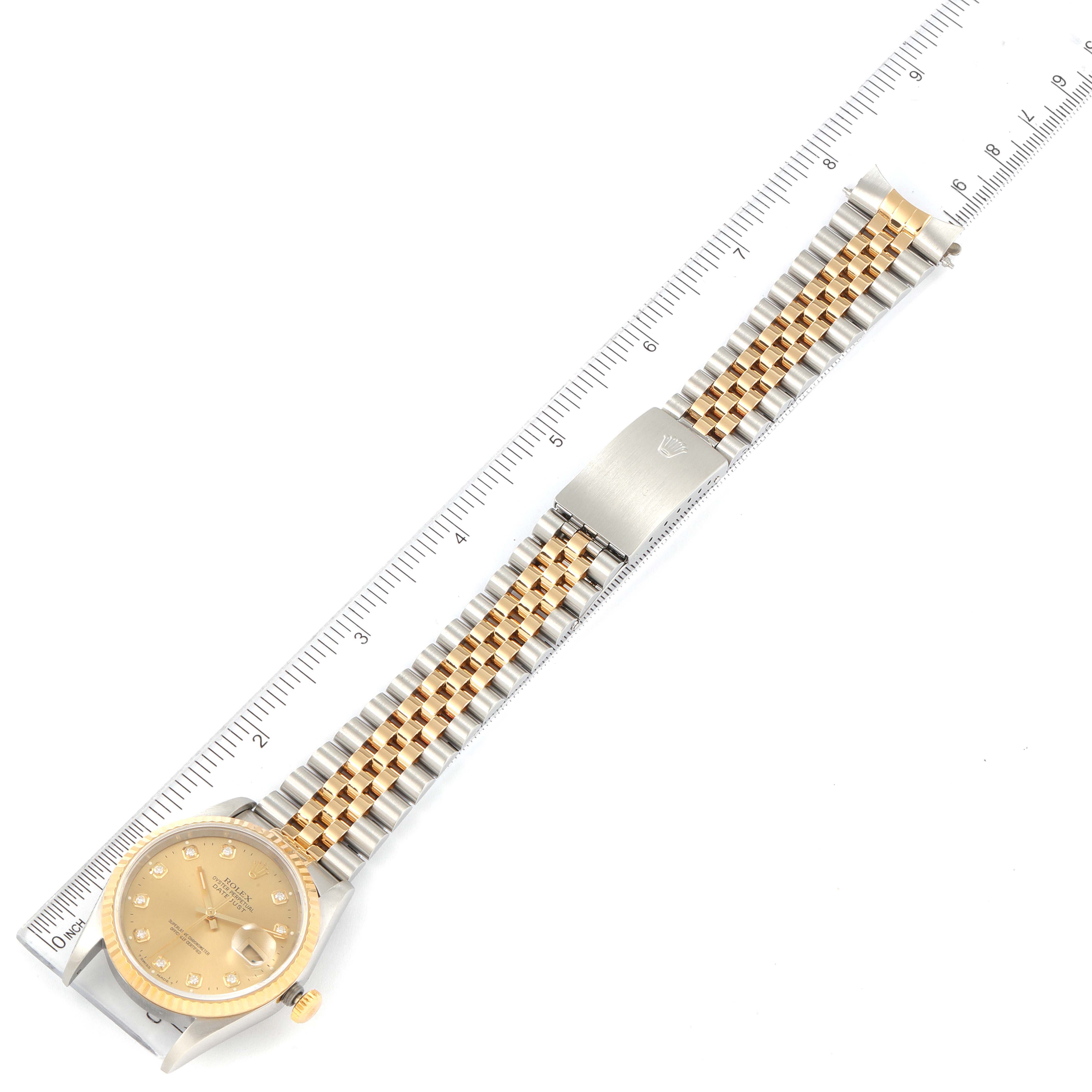 The Rolex Datejust 16233 Men's Steel and Gold (two tone) Champagne Dial 16233 Men's Steel and Gold (two tone) Champagne Dial watch is displayed from a top view, showing the full bracelet and face next to a ruler.