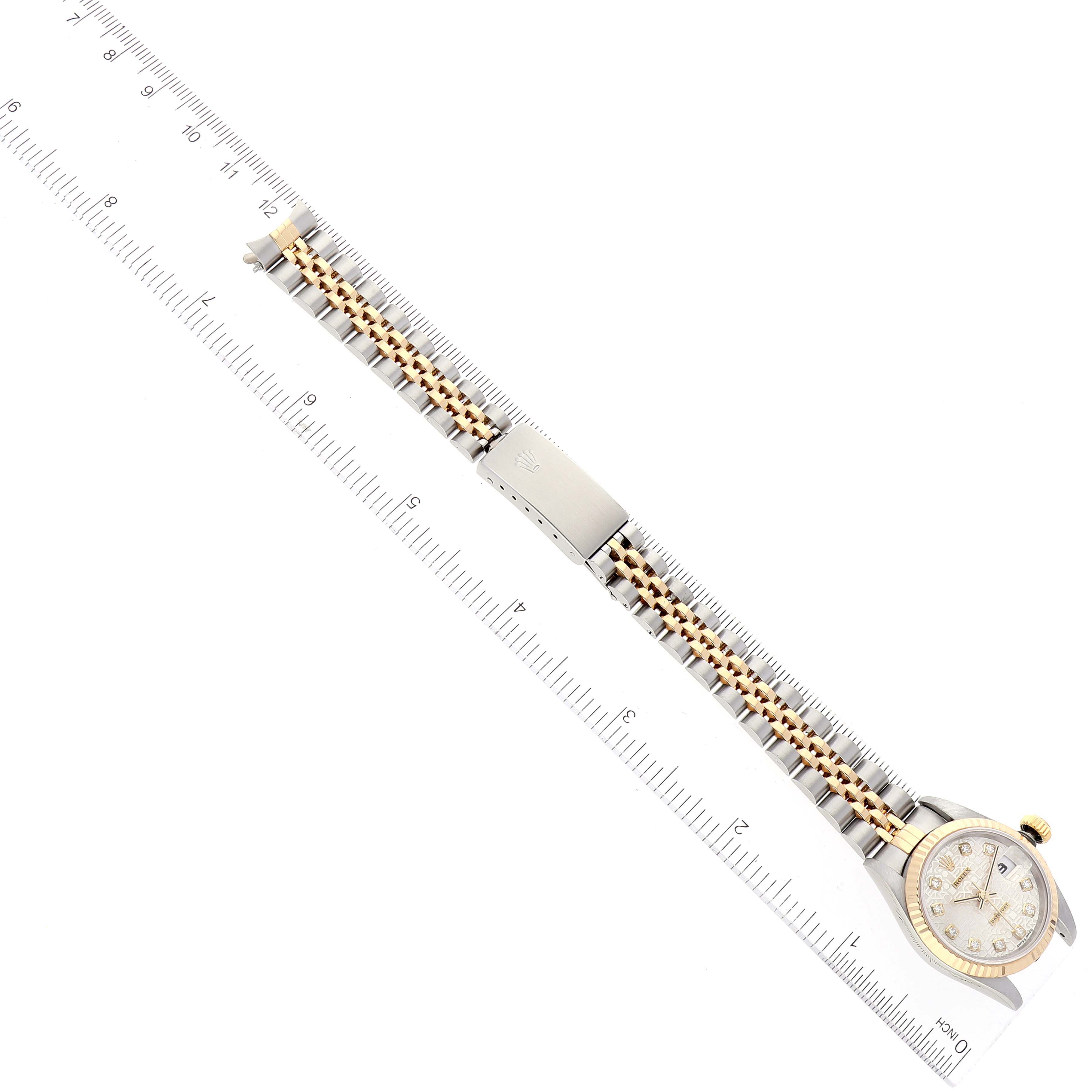 The Rolex Datejust 69173 Women's Steel and Gold (two tone) Silver Dial 69173 Women's Steel and Gold (two tone) Silver Dial watch is shown from a top-down angle with a ruler, displaying the face, bracelet, and clasp.