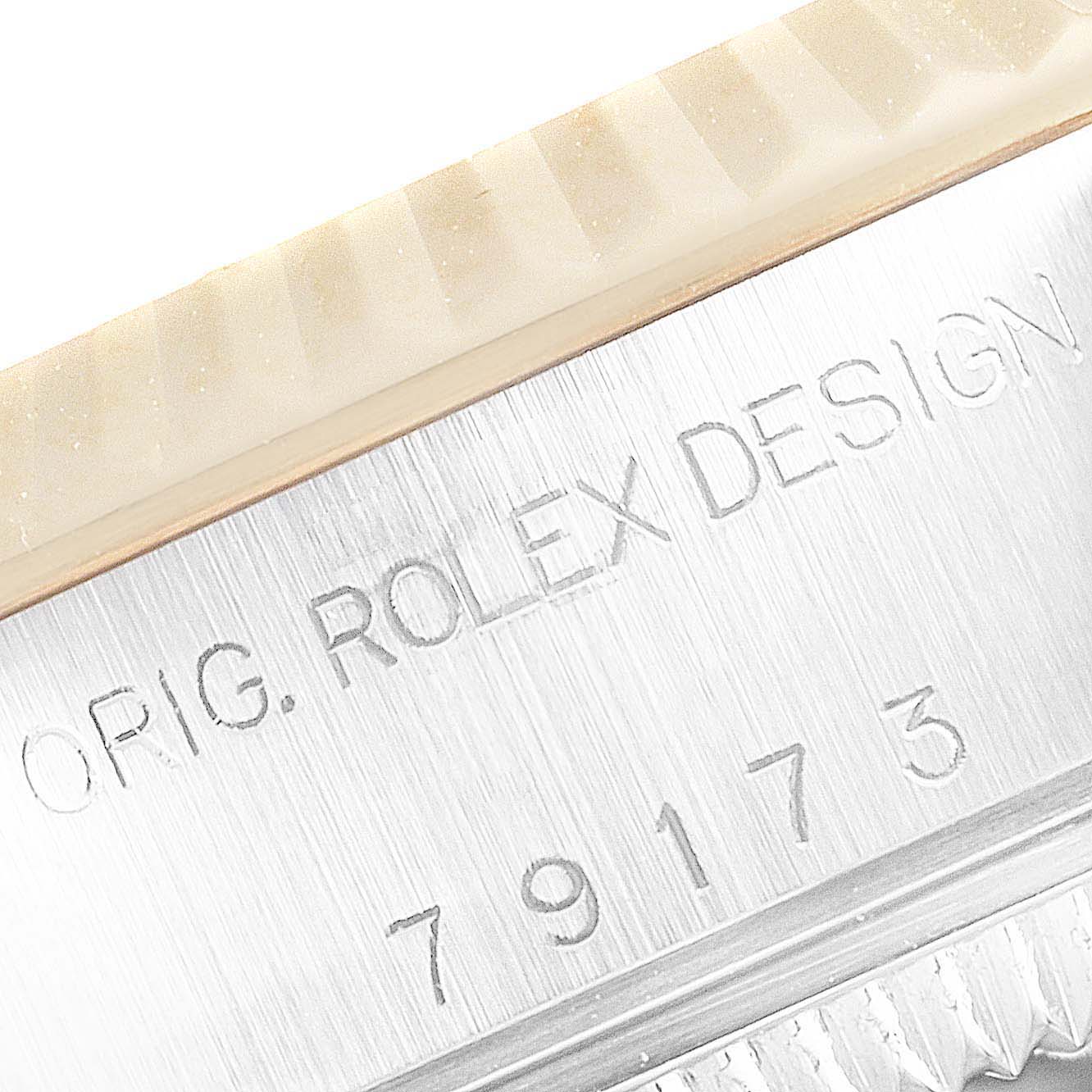 This image shows a close-up of the case side of the Rolex Datejust 79173 Women's Steel and Gold (two tone) Champagne Dial 79173 Women's Steel and Gold (two tone) Champagne Dial watch, featuring the engraved text and serial number.