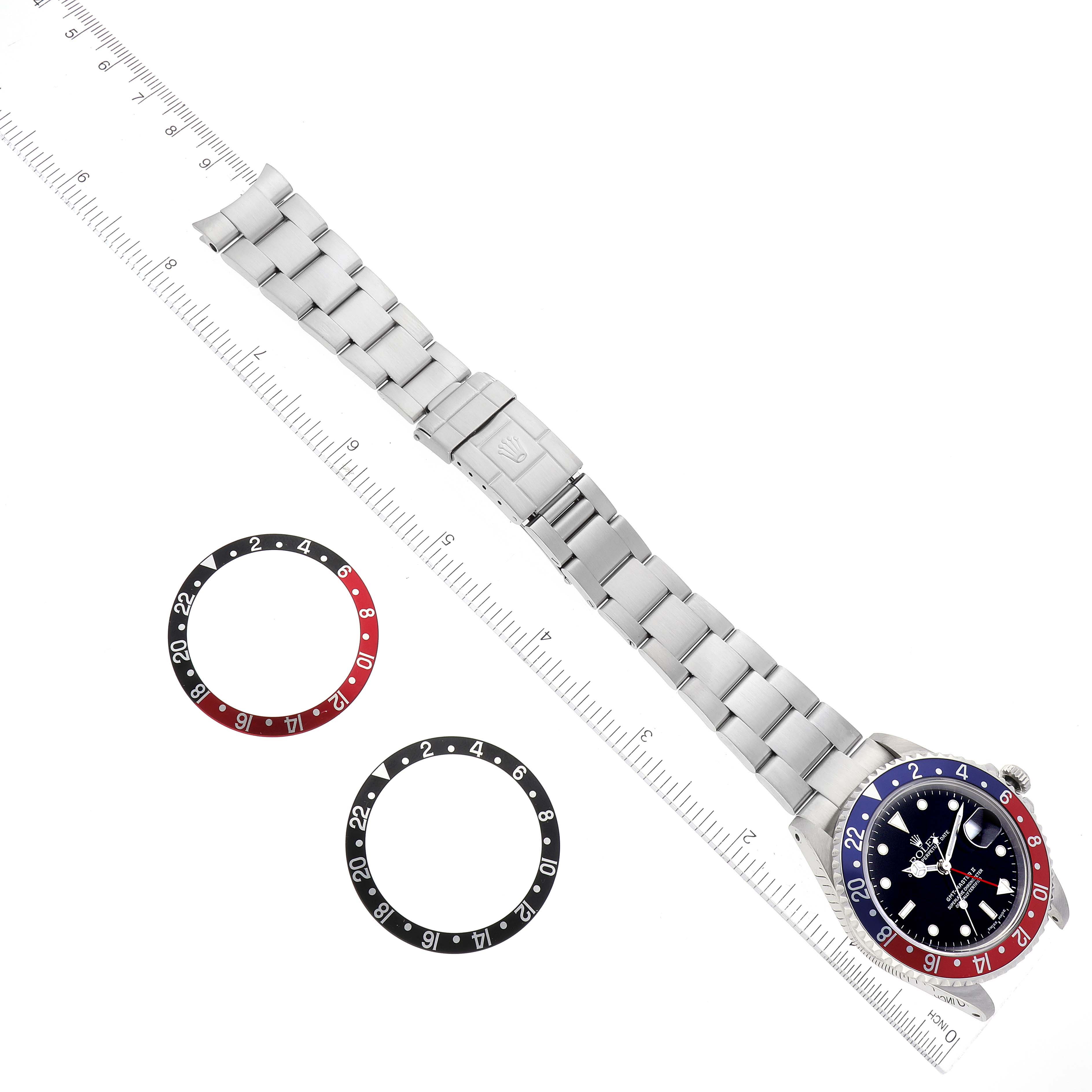 The image shows a top-down view of a Rolex GMT-Master 16710 Men
s Stainless Steel Black Dial 16710 Men
s Stainless Steel Black Dial watch with interchangeable bezels and part of the bracelet.
