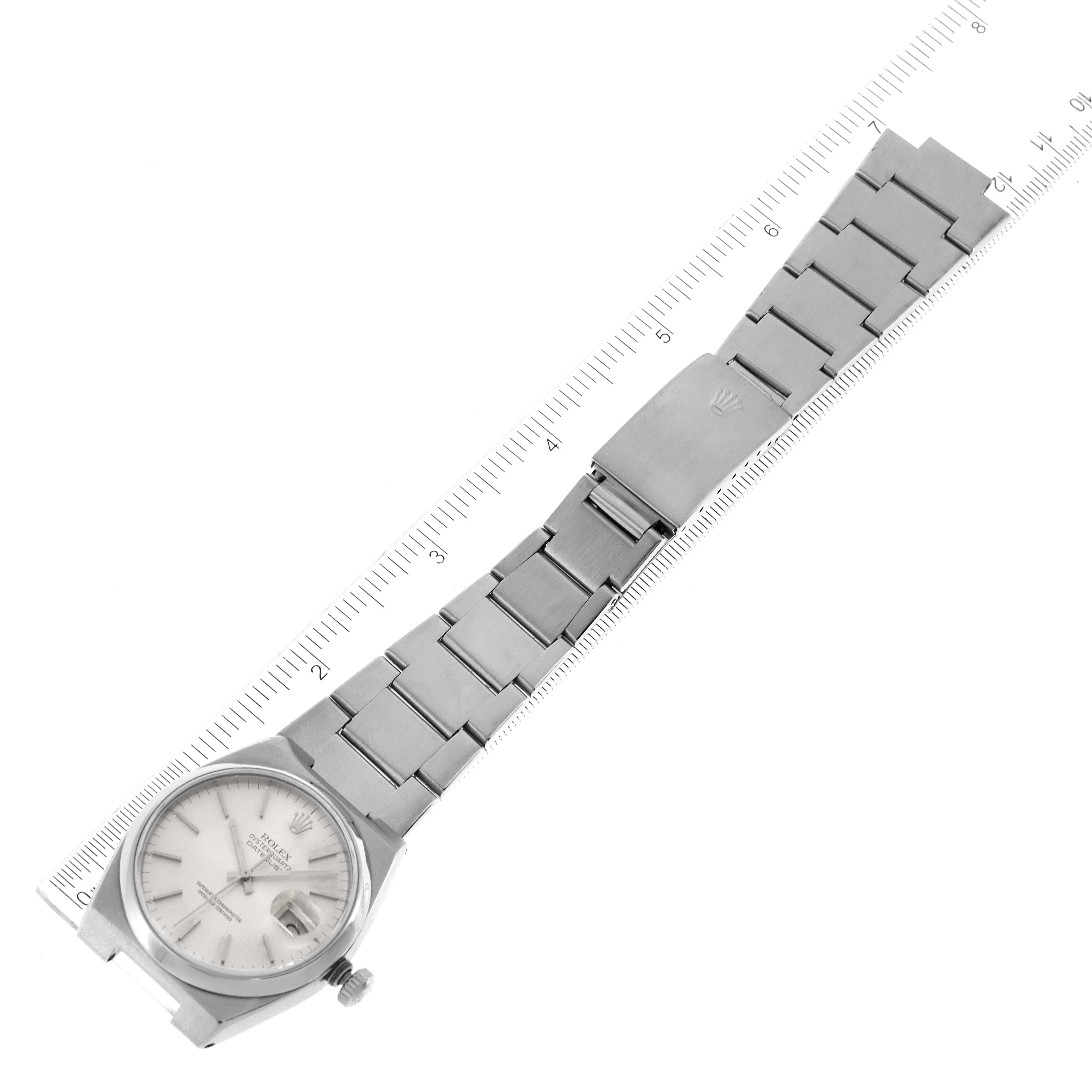 This image shows a top-down view of a Rolex Oysterquartz 17000 Men's Stainless Steel Silver Dial 17000 Men's Stainless Steel Silver Dial watch, displaying the face, bracelet, clasp, and a measuring ruler.