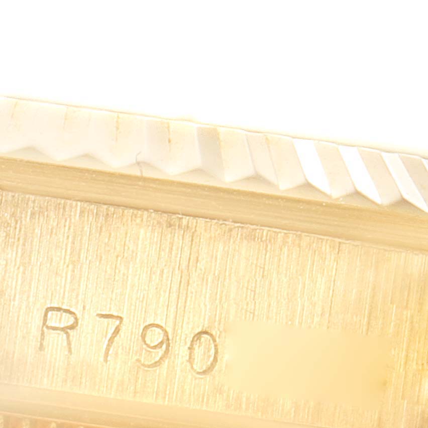 This close-up image shows the Rolex President 68278 Women
s Yellow Gold Champagne Dial 68278 Women
s Yellow Gold Champagne Dial model
s serial number, alongside part of the fluted bezel.