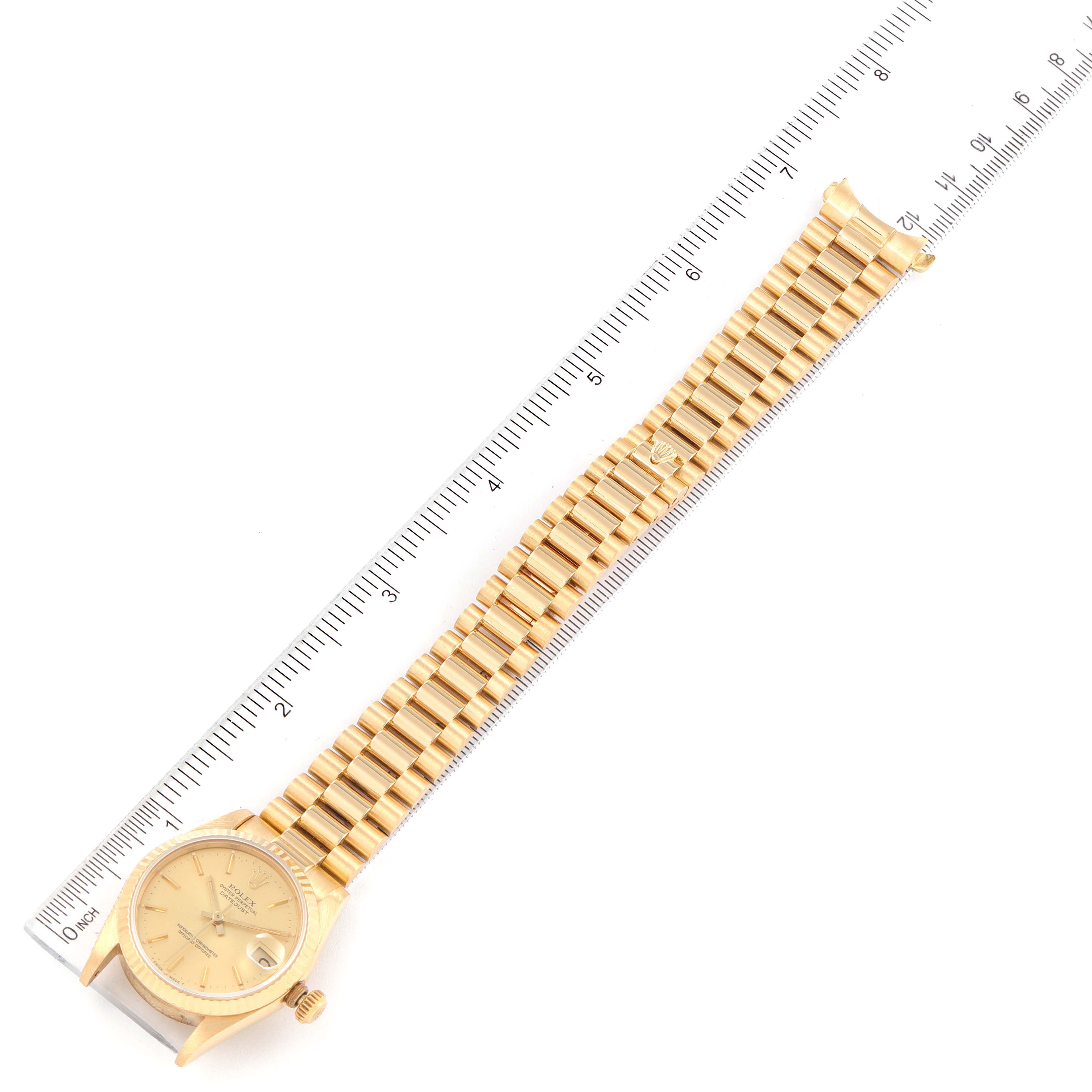 The image shows a full, top-down view of the Rolex President 68278 Women
s Yellow Gold Champagne Dial 68278 Women
s Yellow Gold Champagne Dial model watch, including the dial and bracelet, against a ruler for scale.