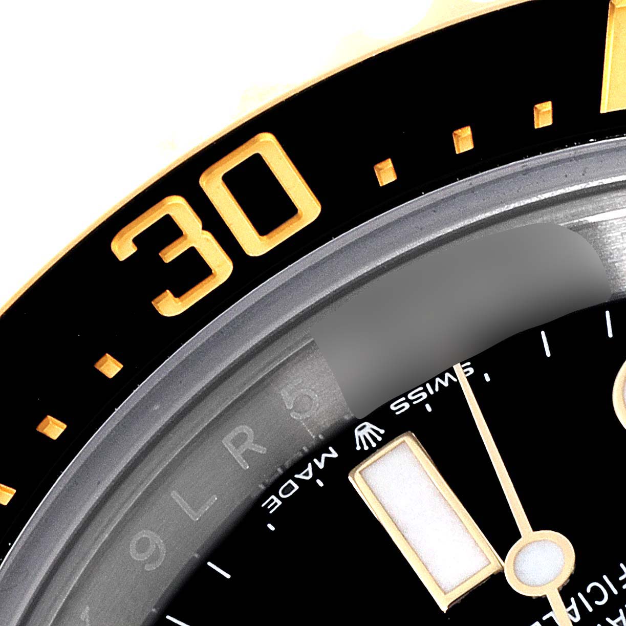 This close-up of a Rolex Sea-Dweller 126603 Men's Steel and Gold (two tone) Black Dial 126603 Men's Steel and Gold (two tone) Black Dial watch shows the bezel at the 30-minute mark and part of the watch's dial.