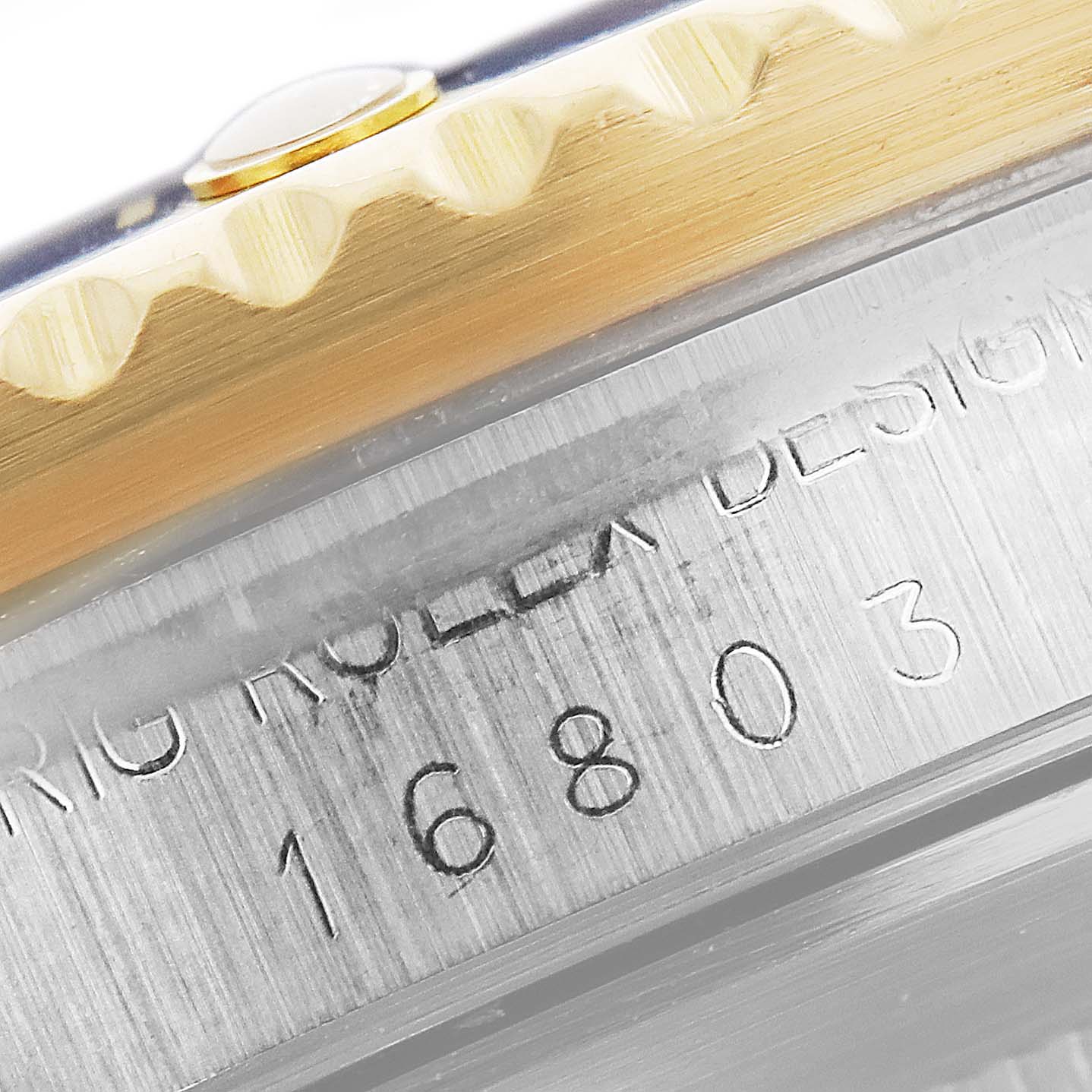 This close-up image shows the side of the bezel and the engraved case of the Rolex Submariner 16803 Men
s Steel and Gold (two tone) Blue Dial 16803 Men
s Steel and Gold (two tone) Blue Dial model 16803.