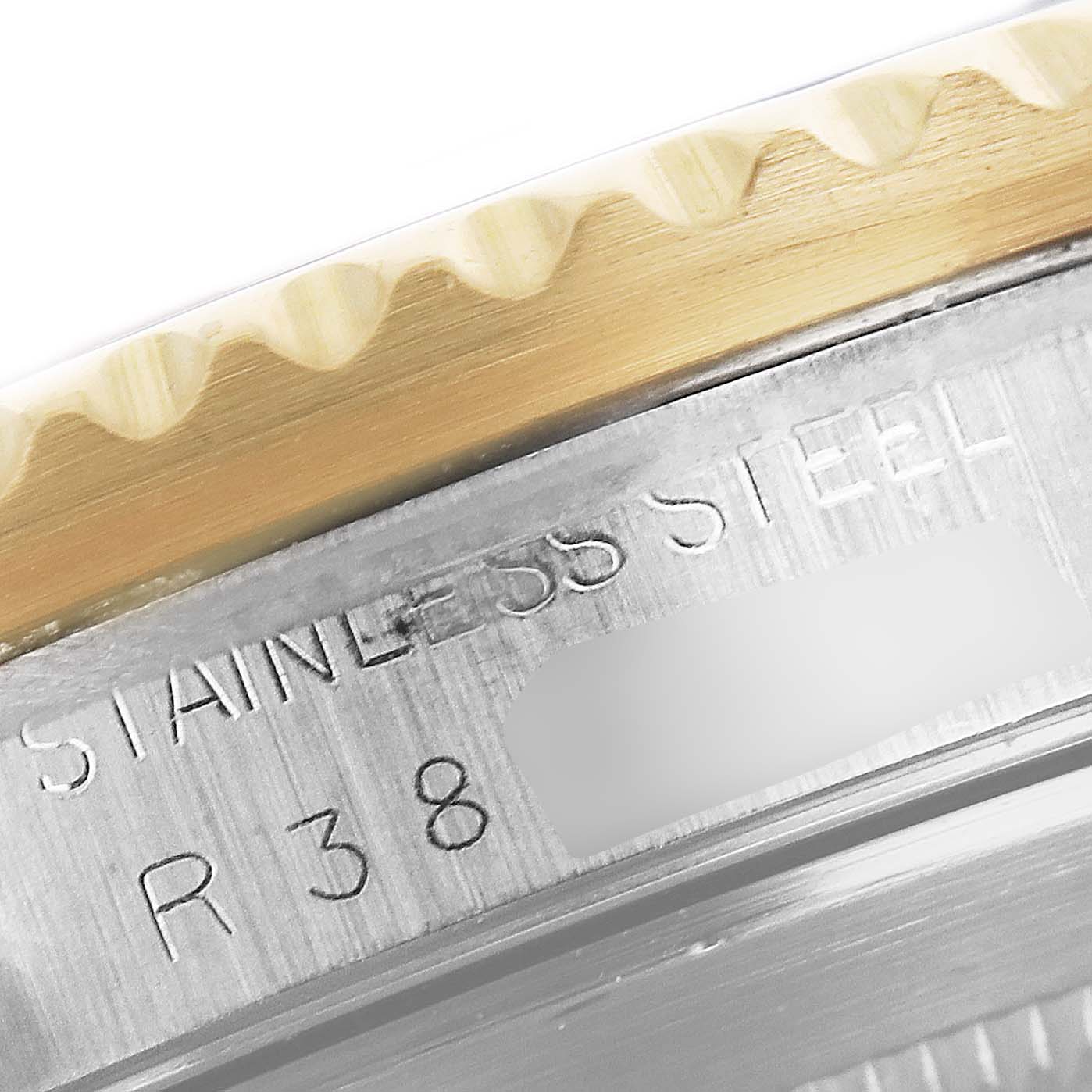 This close-up image shows the engraved stainless steel marking and partially visible serial number on a Rolex Submariner 16803 Men
s Steel and Gold (two tone) Blue Dial 16803 Men
s Steel and Gold (two tone) Blue Dial watch.