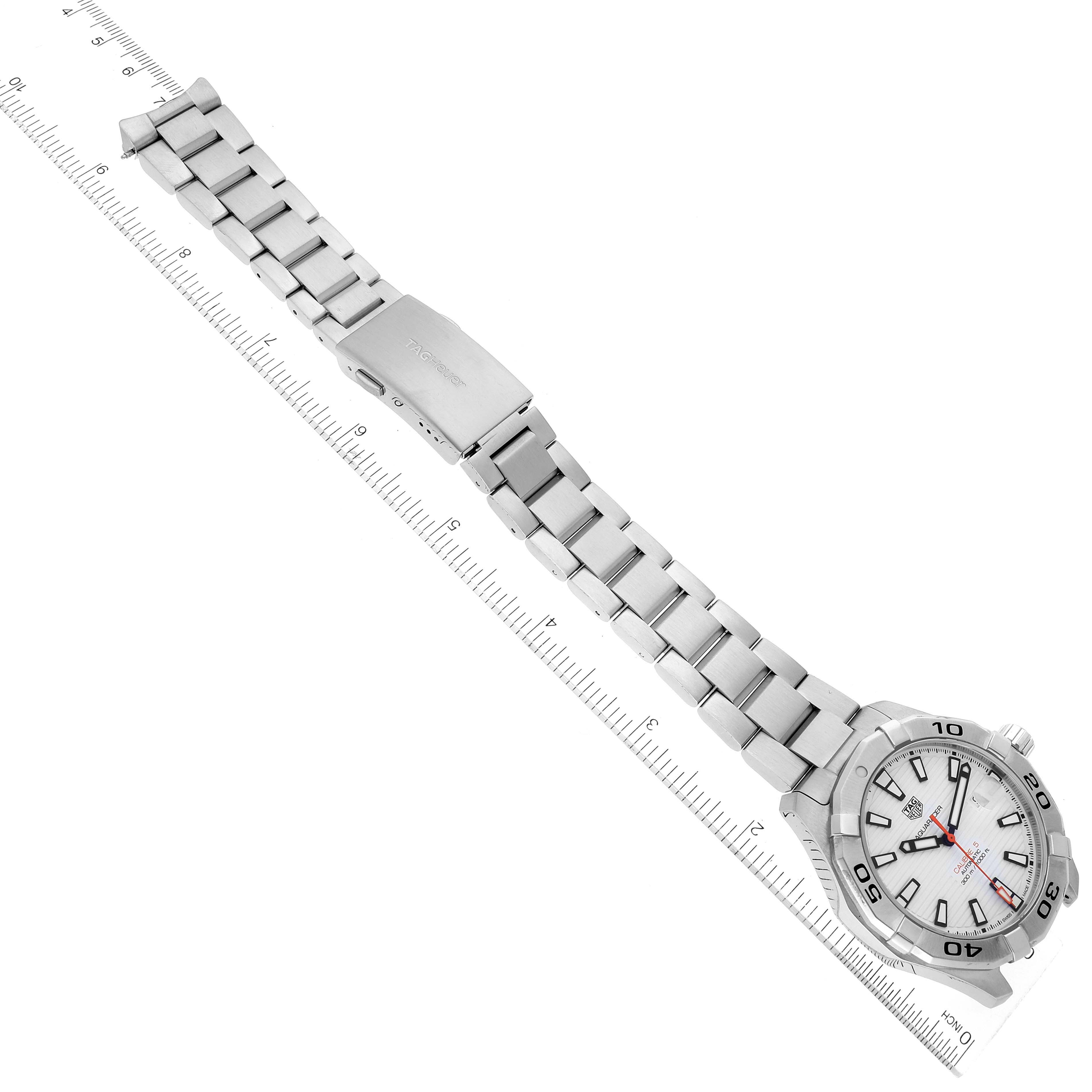 This image shows a Tag Heuer Aquaracer WAY2013.BA0927 Men's Stainless Steel White Dial WAY2013.BA0927 Men's Stainless Steel White Dial watch laying flat with its stainless steel bracelet fully extended, next to a ruler for scale.