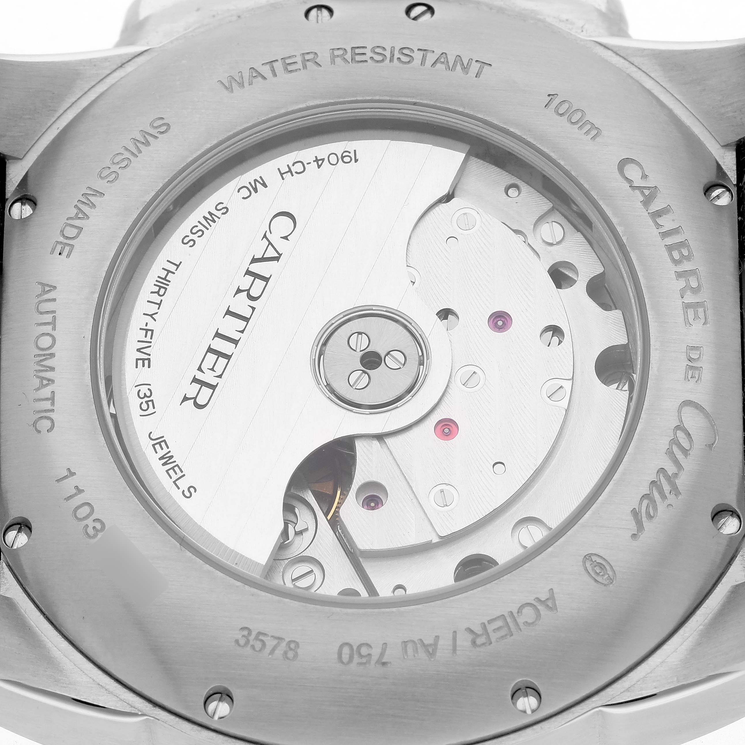 The Calibre de Cartier watch is shown from the back, displaying its automatic movement and rotor mechanism through the transparent case back.
