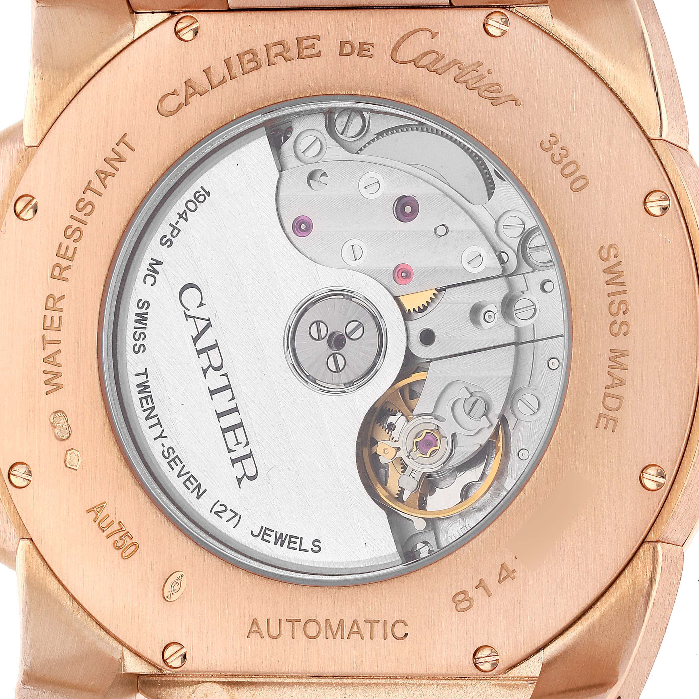 The image shows the back side of the Calibre de Cartier watch, highlighting the automatic movement and internal mechanics.