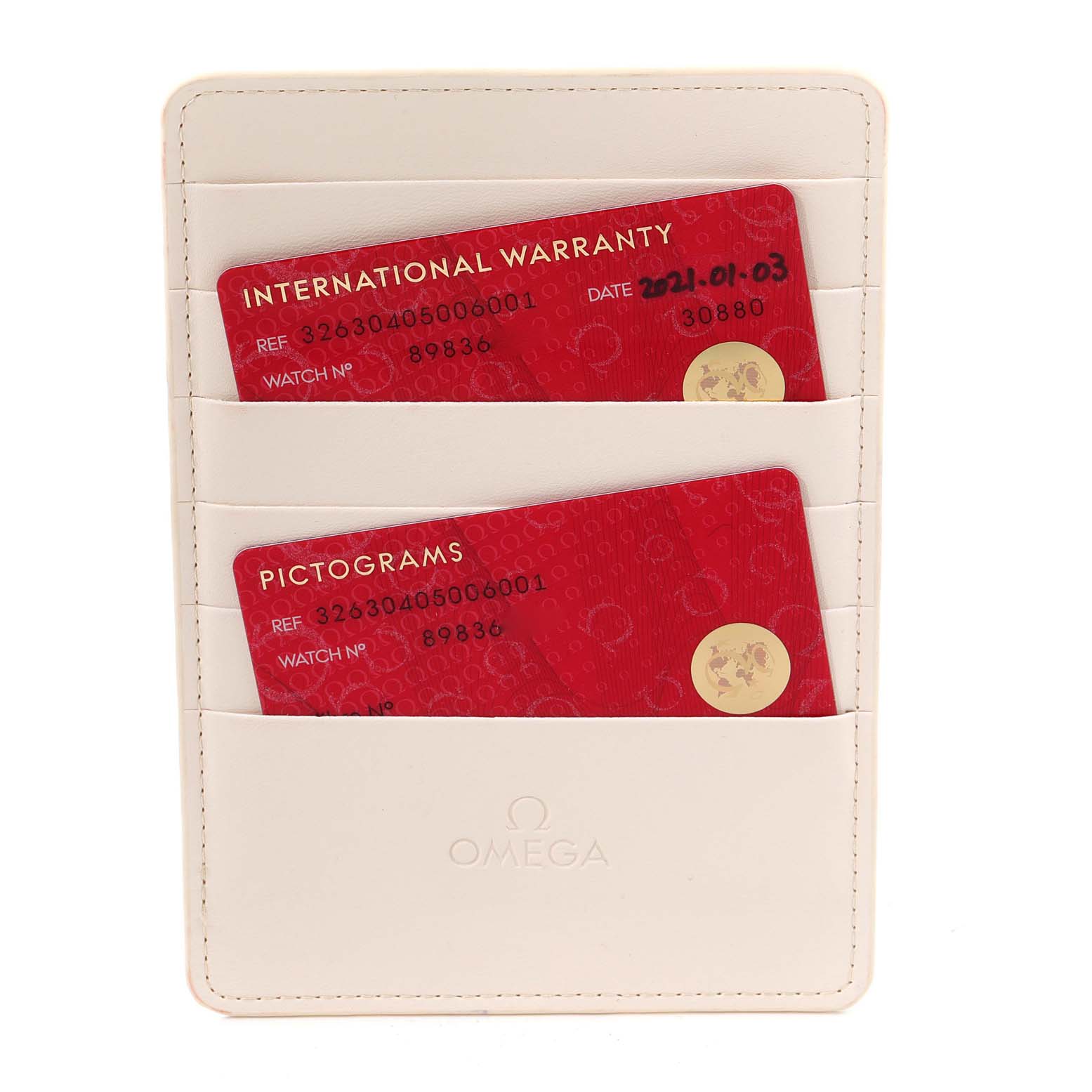 The image shows the international warranty and pictograms cards for an Omega Speedmaster 326.30.40.50.06.001 Men's Stainless Steel Grey Dial 326.30.40.50.06.001 Men's Stainless Steel Grey Dial watch, held in a white cardholder.