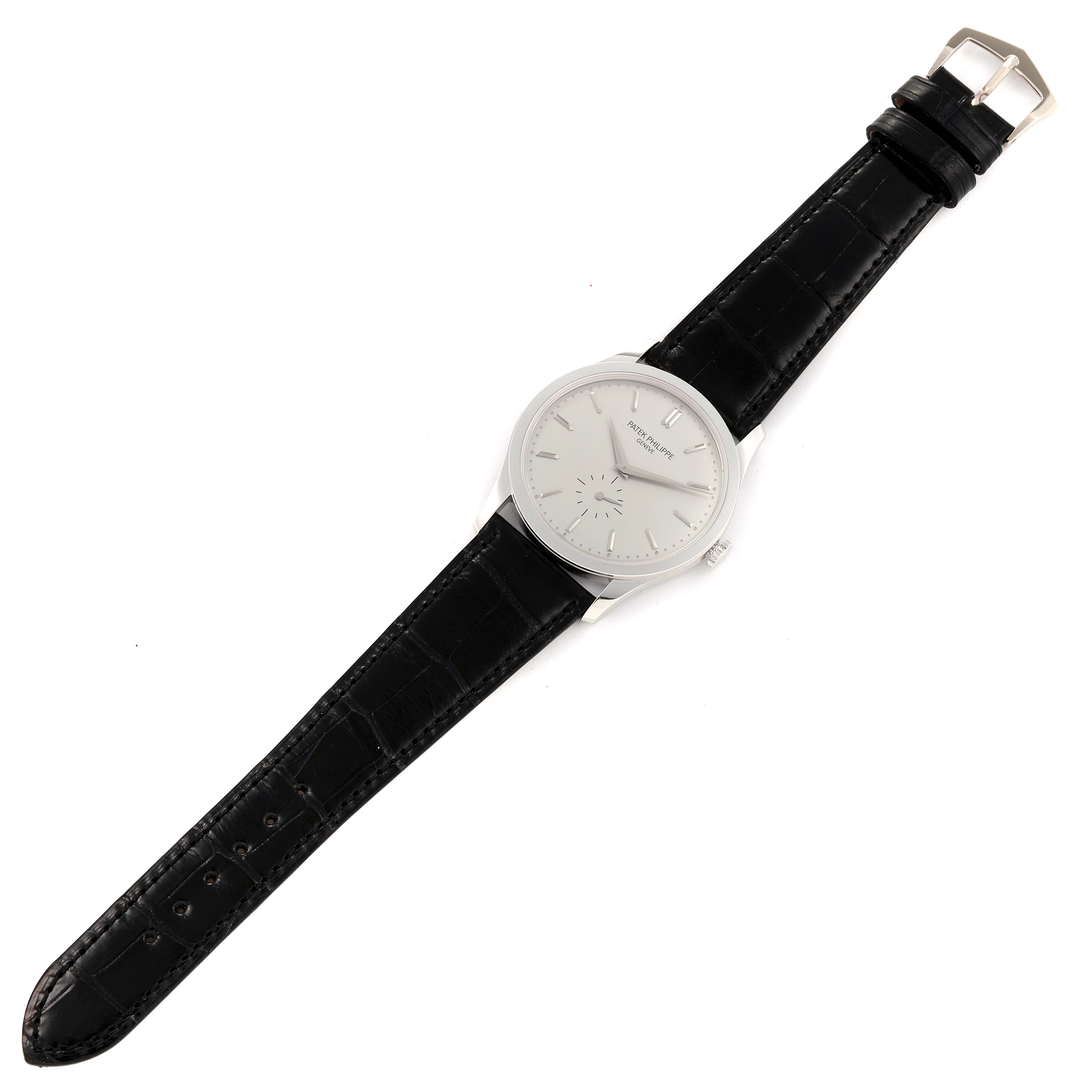 The image shows a top-down view of a Patek Philippe Calatrava 5196G Men's White Gold Silver Dial 5196G Men's White Gold Silver Dial watch featuring its dial, case, and black leather strap.