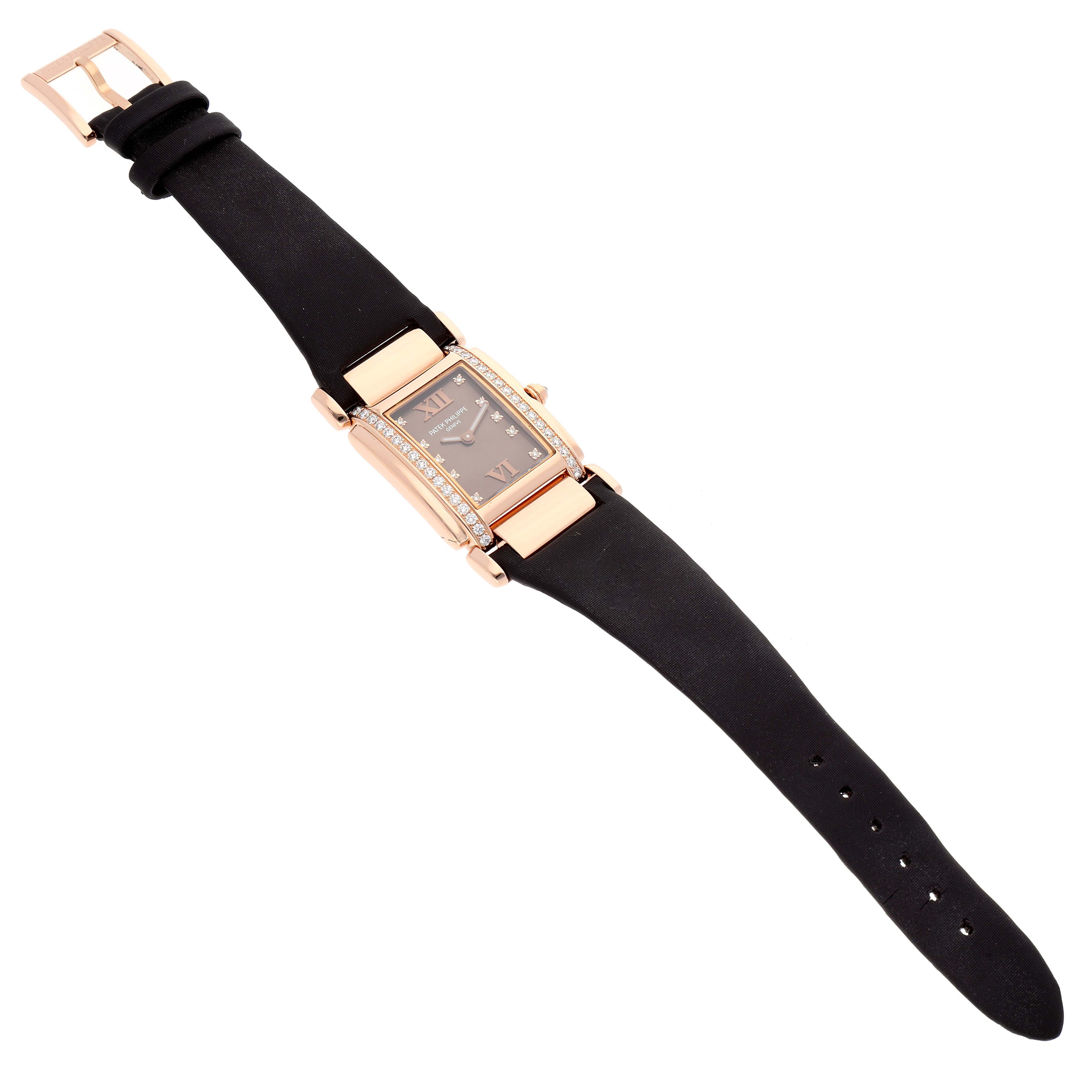 The image shows a top-down view of a Patek Philippe Twenty-4 4920R-10 Women's Rose Gold Brown Dial 4920R-10 Women's Rose Gold Brown Dial watch featuring a black strap and a rectangular, diamond-studded face.