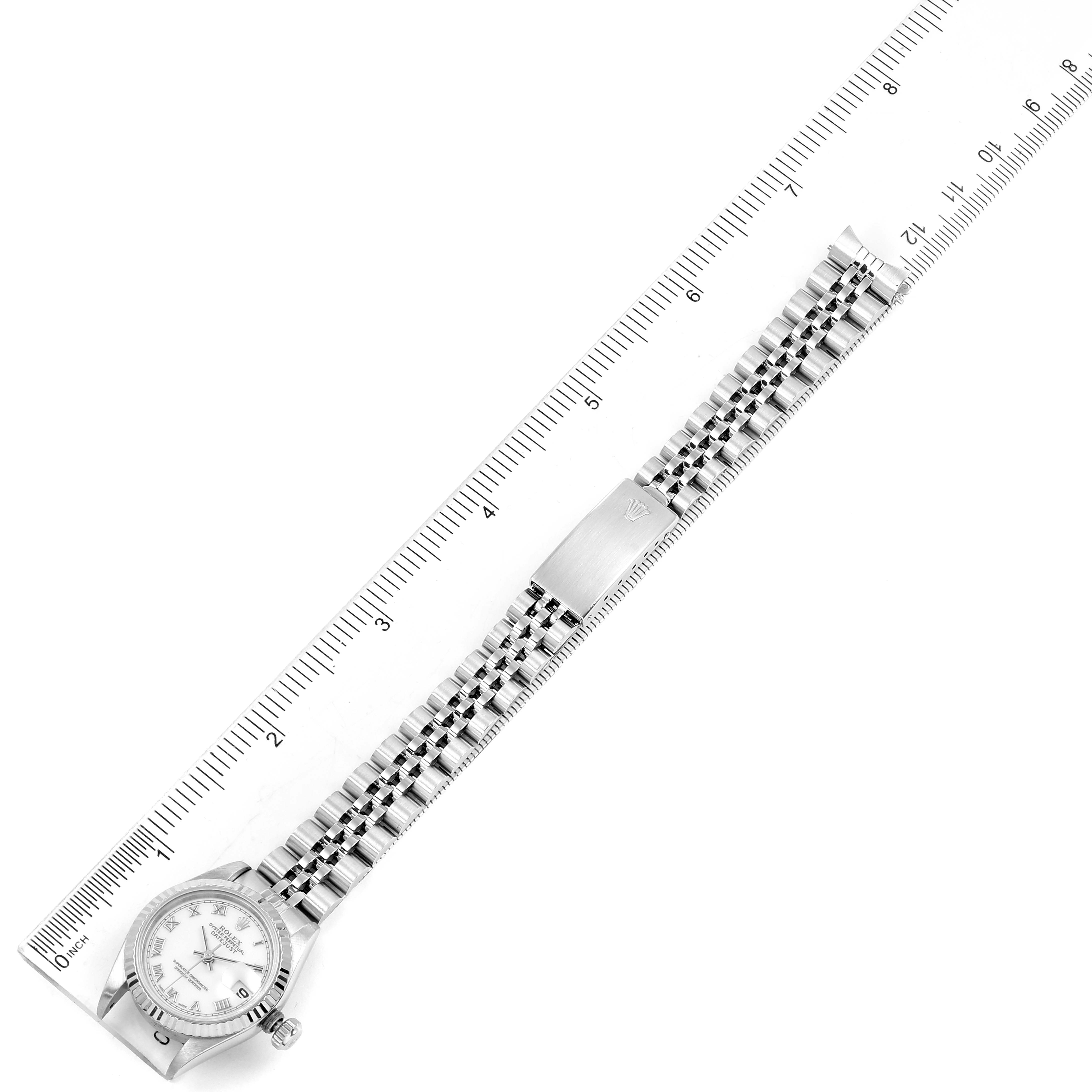 This image shows a Rolex Datejust 69174 Women's Stainless Steel White Dial 69174 Women's Stainless Steel White Dial watch at a top-down angle, displaying the entire bracelet and face alongside a ruler.