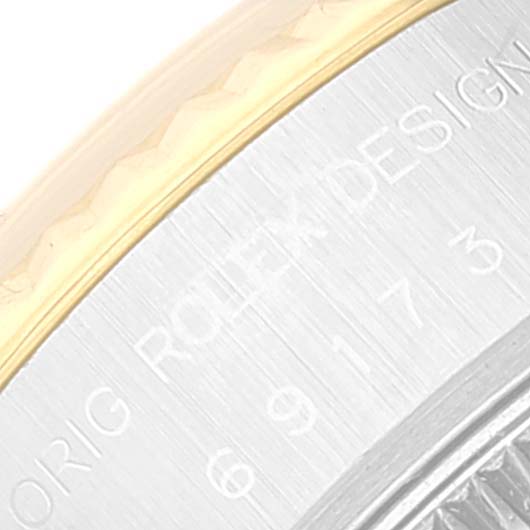 This close-up image of a Rolex Datejust 69173 Women's Steel and Gold (two tone) Black Dial 69173 Women's Steel and Gold (two tone) Black Dial watch shows part of the bezel and the engravings on the case.