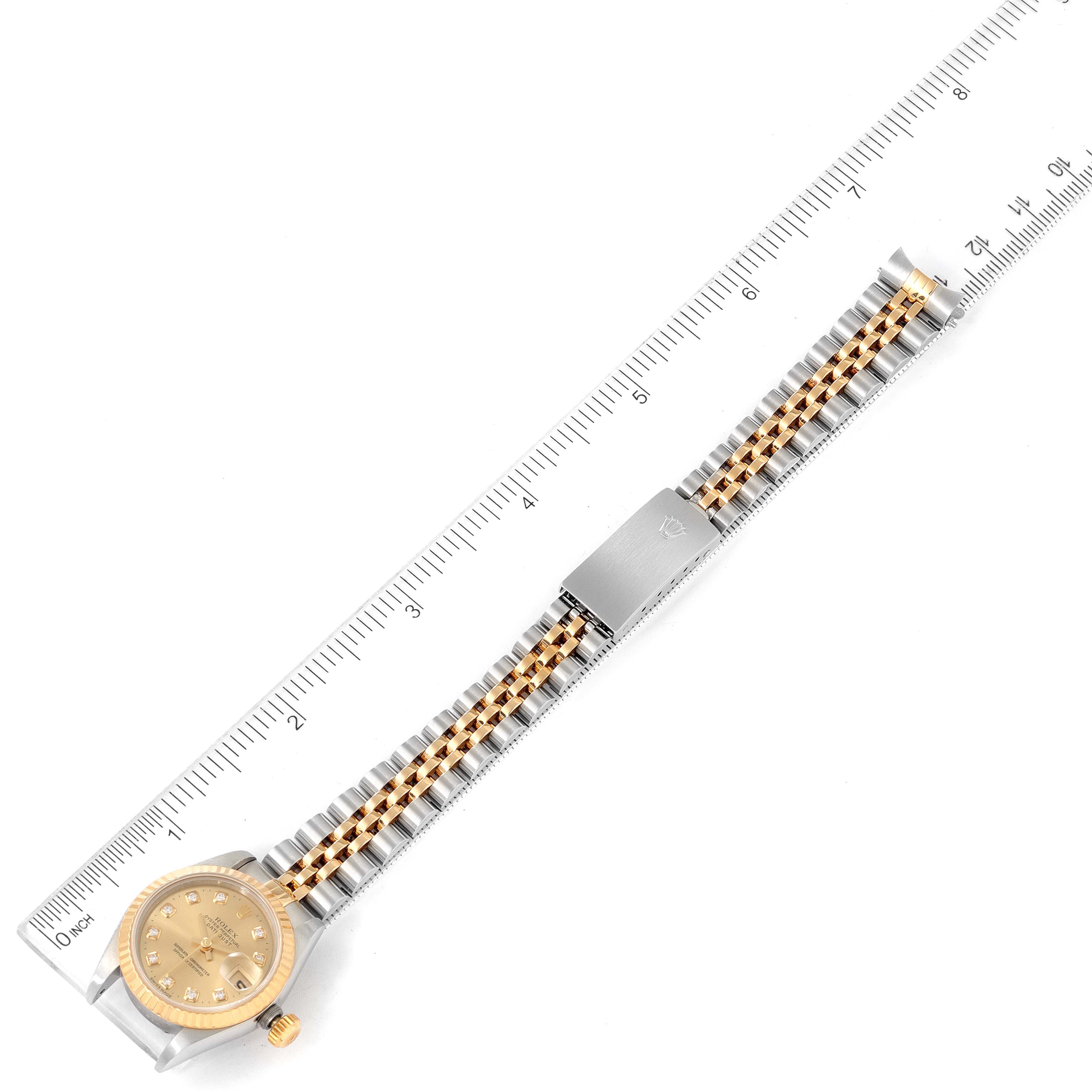The image shows a Rolex Datejust 69173 Women
s Steel and Gold (two tone) Champagne Dial 69173 Women
s Steel and Gold (two tone) Champagne Dial watch from an overhead angle, displaying the dial, bezel, and bracelet alongside a ruler for scale.
