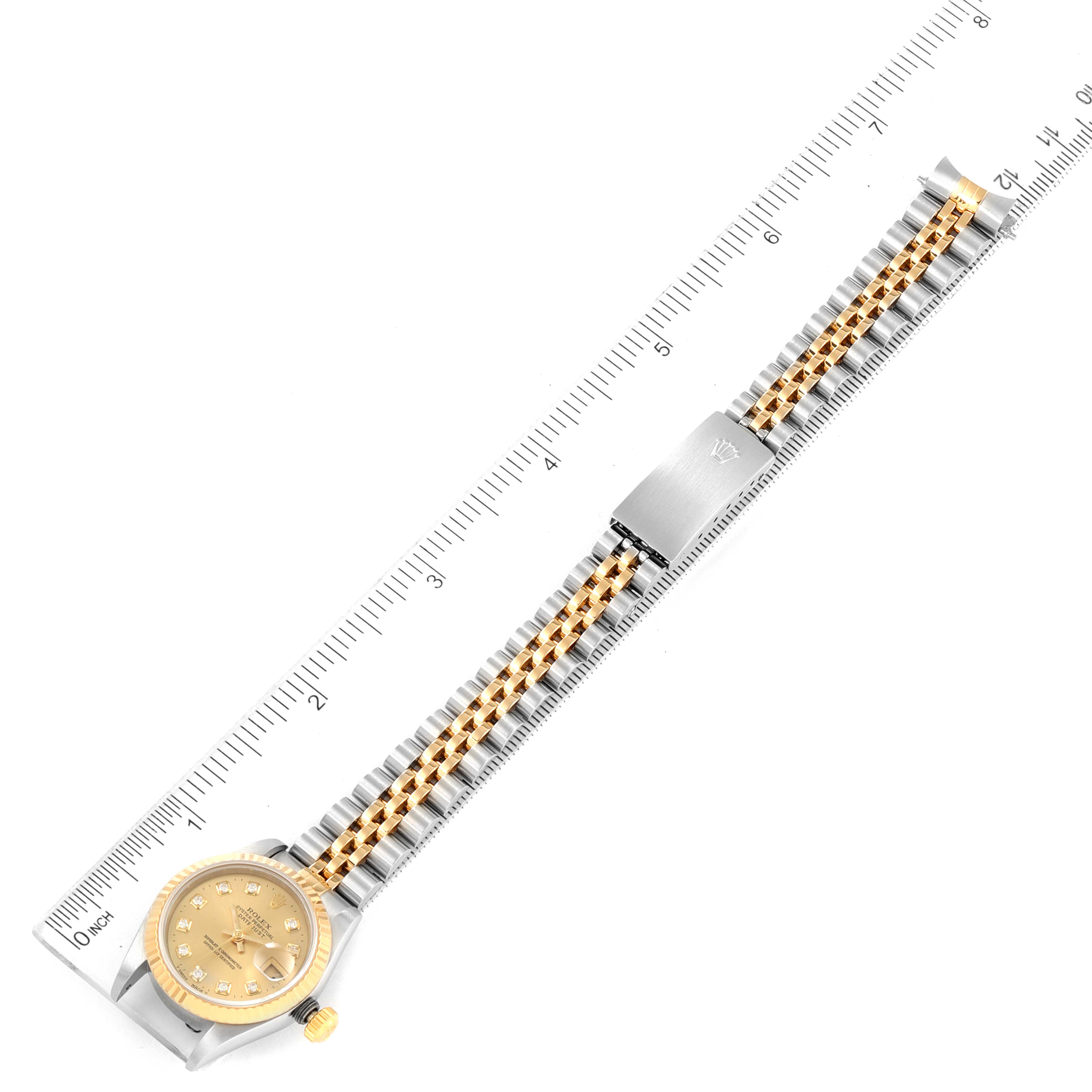 The image shows a top view of a Rolex Datejust 40895 Women
s Steel and Gold (two tone) Champagne Dial 40895 Women
s Steel and Gold (two tone) Champagne Dial watch with a ruler for size reference.