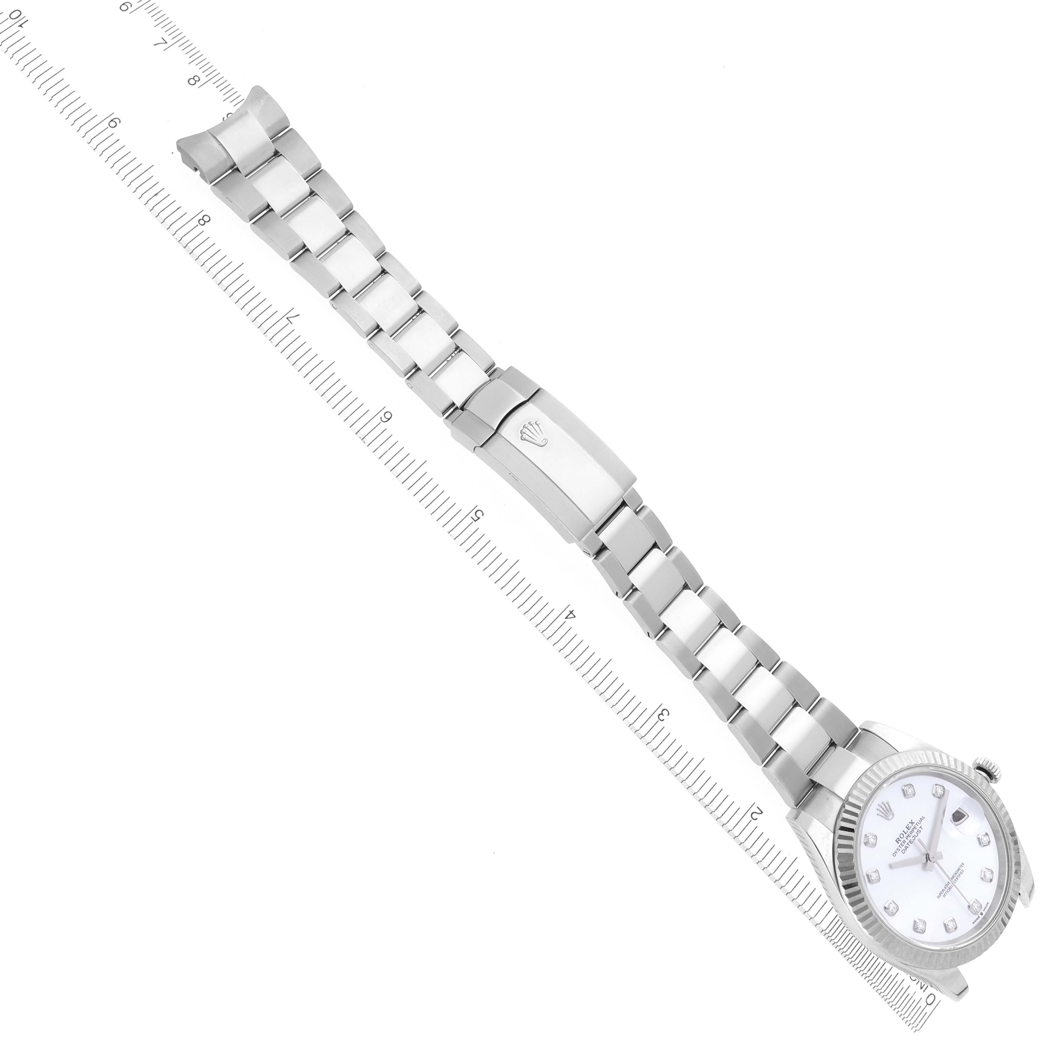 The Rolex Datejust 41 126334NG Men's Stainless Steel Mother of Pearl Dial 126334NG Men's Stainless Steel Mother of Pearl Dial watch is shown from a top-down angle, featuring the full bracelet and clasp with a visible ruler for scale.