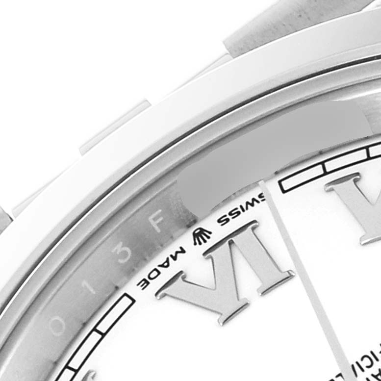 This close-up image of a Rolex Datejust 41 126300 Men
s Stainless Steel White Dial 126300 Men
s Stainless Steel White Dial watch shows the edge of the dial, bezel, and part of the Roman numeral VI.