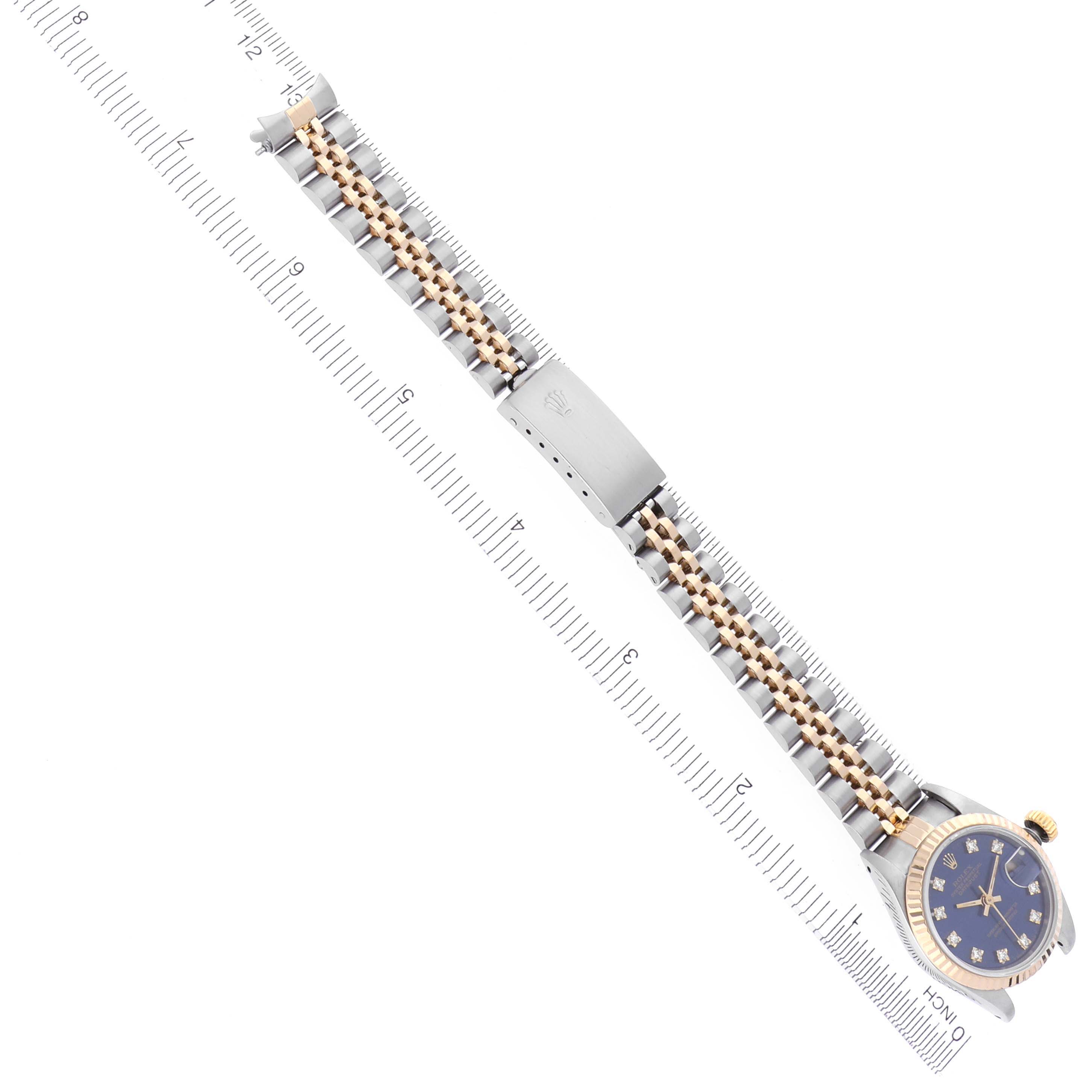 The Rolex Datejust 69173 Women's Steel and Gold (two tone) Blue Dial 69173 Women's Steel and Gold (two tone) Blue Dial watch is shown from an overhead angle, highlighting the bracelet and clasp alongside a measuring ruler.
