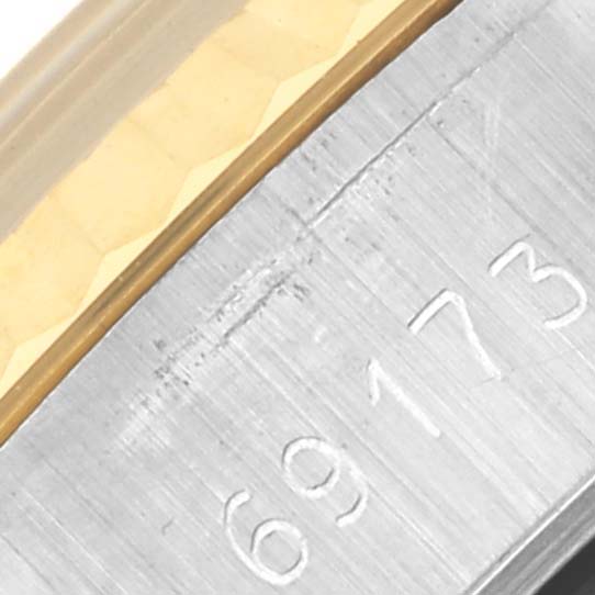The image shows a close-up of the model number engraving and part of the metal bracelet of a Rolex Datejust 69173 Women's Steel and Gold (two tone) Silver Dial 69173 Women's Steel and Gold (two tone) Silver Dial.