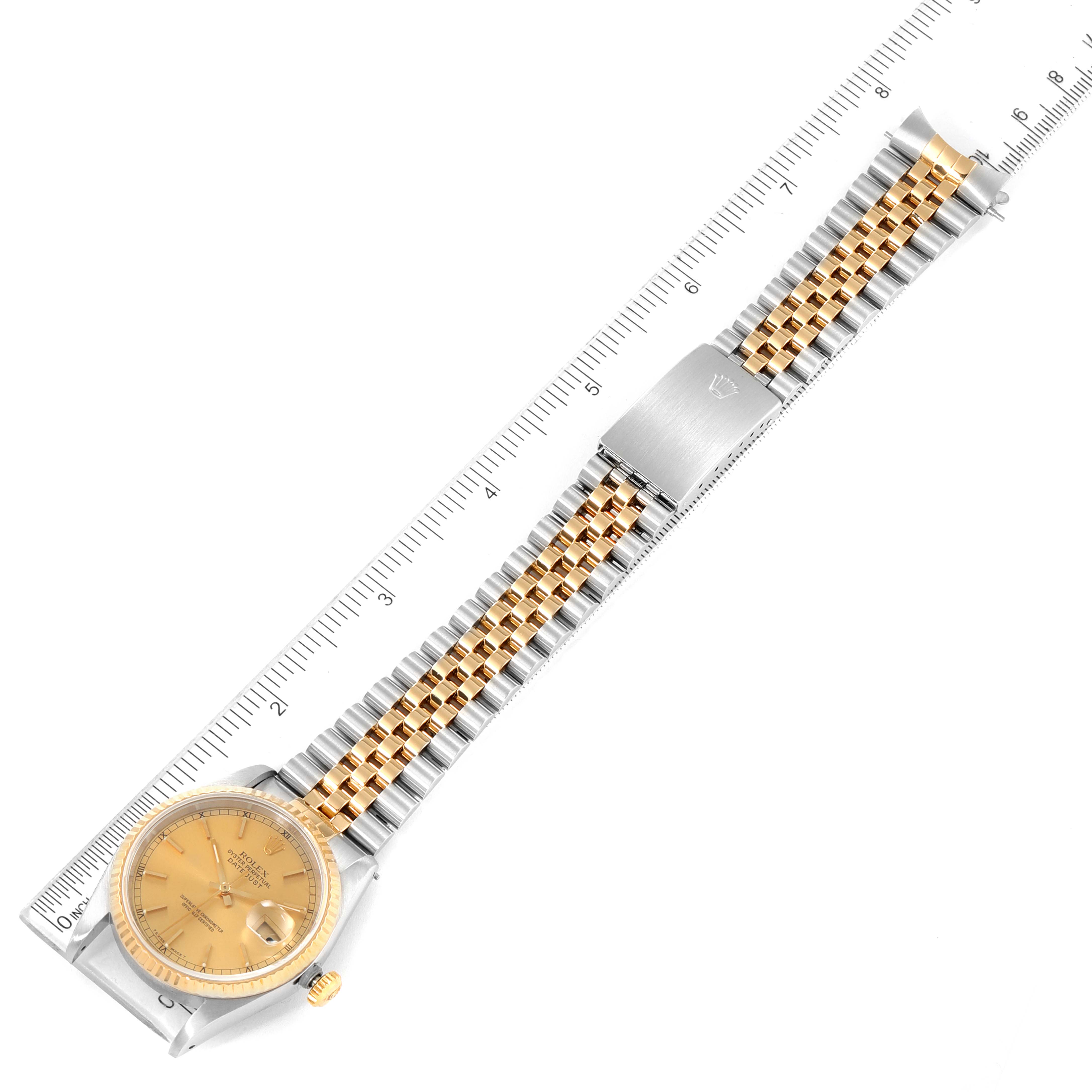 The Rolex Datejust 16233 Men's Steel and Gold (two tone) Champagne Dial 16233 Men's Steel and Gold (two tone) Champagne Dial watch is pictured from an overhead angle, showing the full bracelet and face with a measurement ruler beside it.