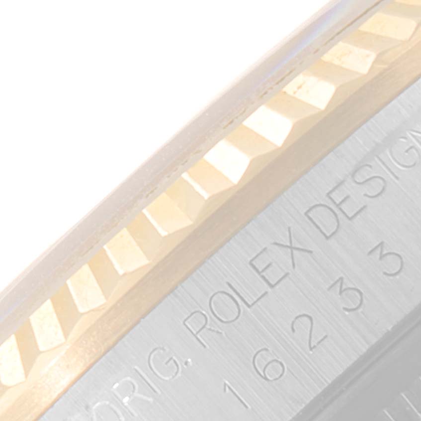 This image shows a Rolex Datejust 16233 Men's Steel and Gold (two tone) Blue Dial 16233 Men's Steel and Gold (two tone) Blue Dial watch's fluted bezel and part of the engraved rehaut.