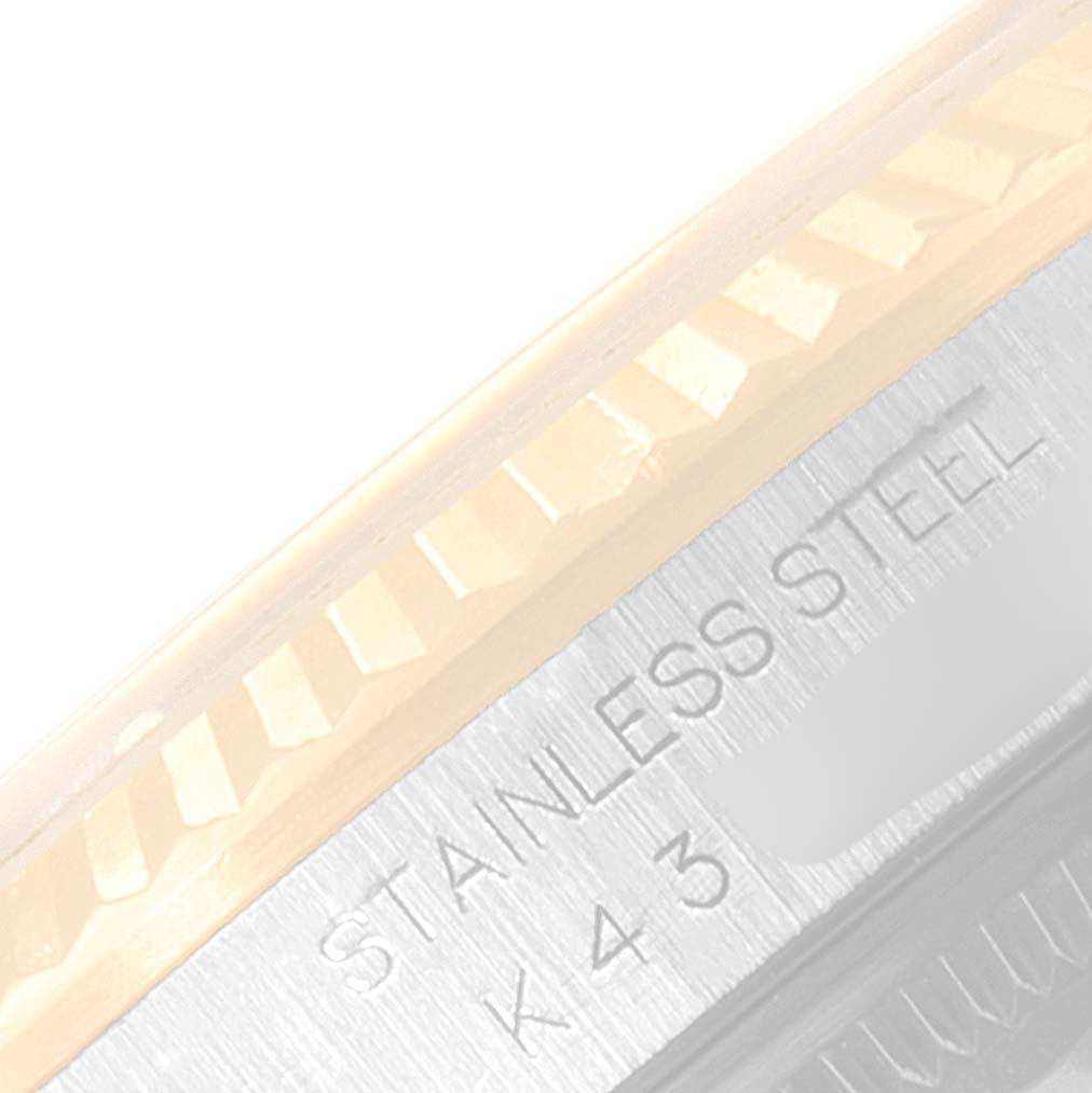 The image shows a close-up angle of the outer edge of a Rolex Datejust 16233 Men's Steel and Gold (two tone) Blue Dial 16233 Men's Steel and Gold (two tone) Blue Dial watch, highlighting its stainless steel material and fluted bezel.