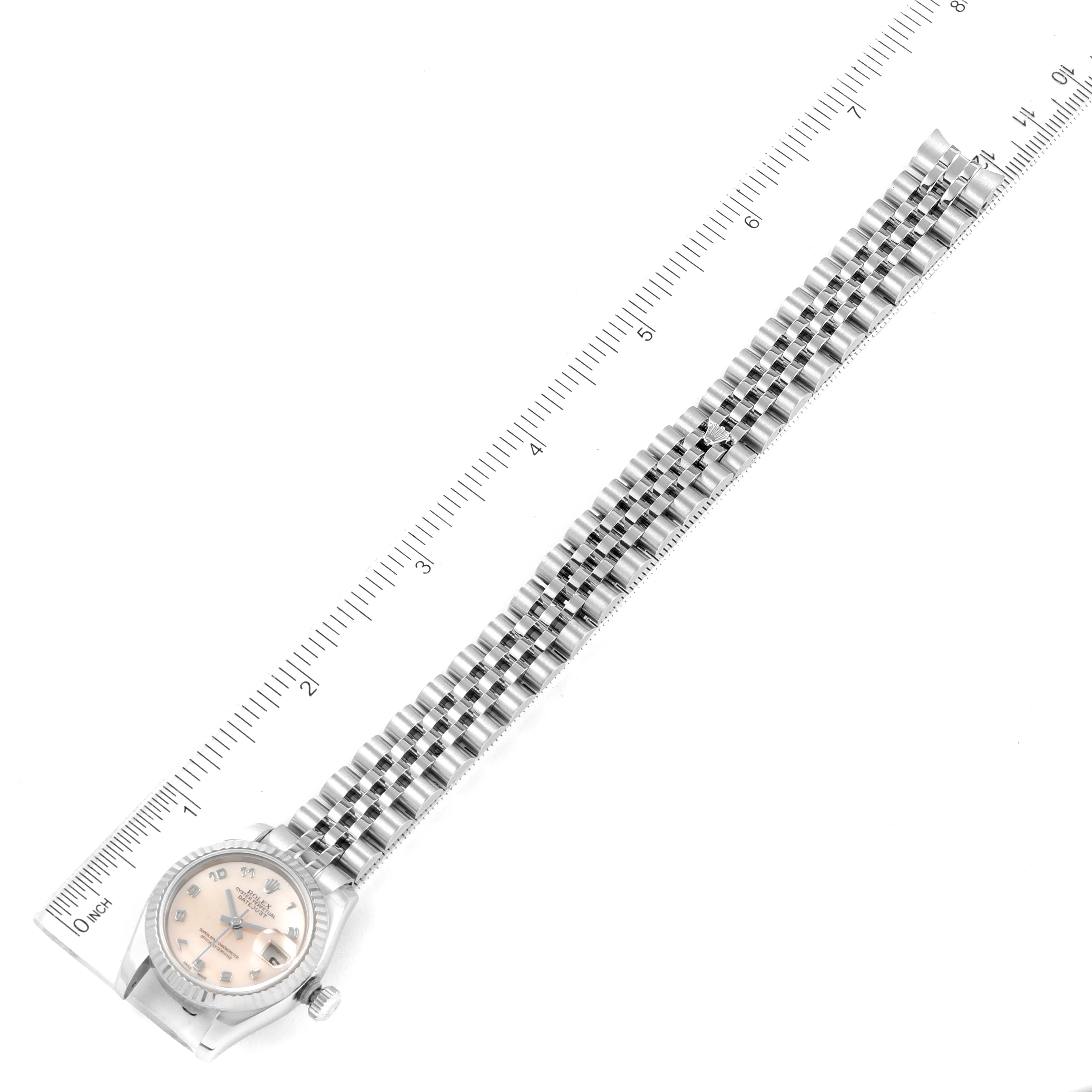 This image shows a Rolex Datejust 179174 Women's Stainless Steel Mother of Pearl Dial 179174 Women's Stainless Steel Mother of Pearl Dial watch laid flat next to a ruler, highlighting its full length and bracelet.