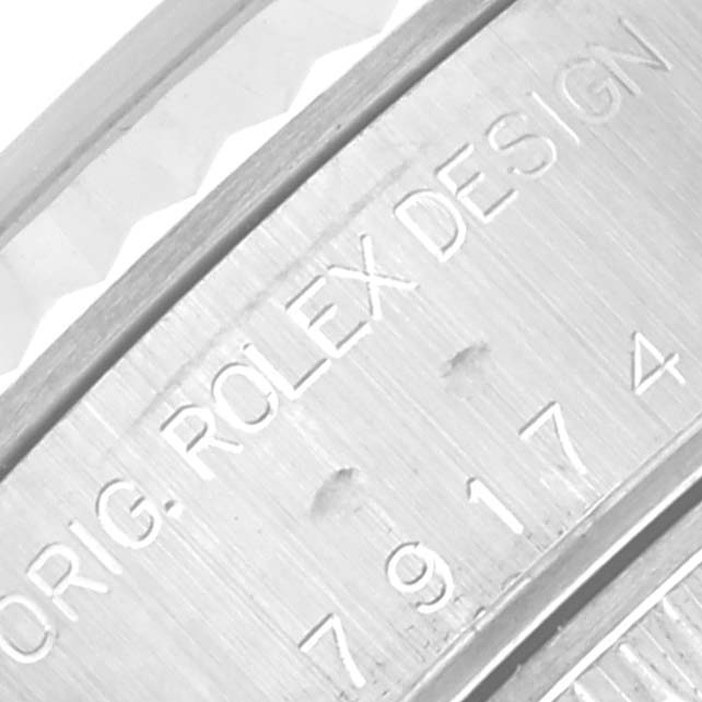 The image shows a close-up of the case side of a Rolex Datejust 79174 Women's Stainless Steel White Dial 79174 Women's Stainless Steel White Dial, highlighting the engraved branding and serial number.